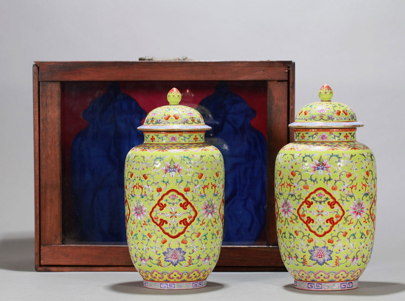 A PAIR OF GREEN-GROUND FAMILLE ROSE 'FLOWERS' COVERED JAR: A PAIR OF GREEN-GROUND FAMILLE ROSE 'FLOWERS' COVERED JAR Dimensions: Height: 24 cm (9.45 in.). All measurements are approximate.