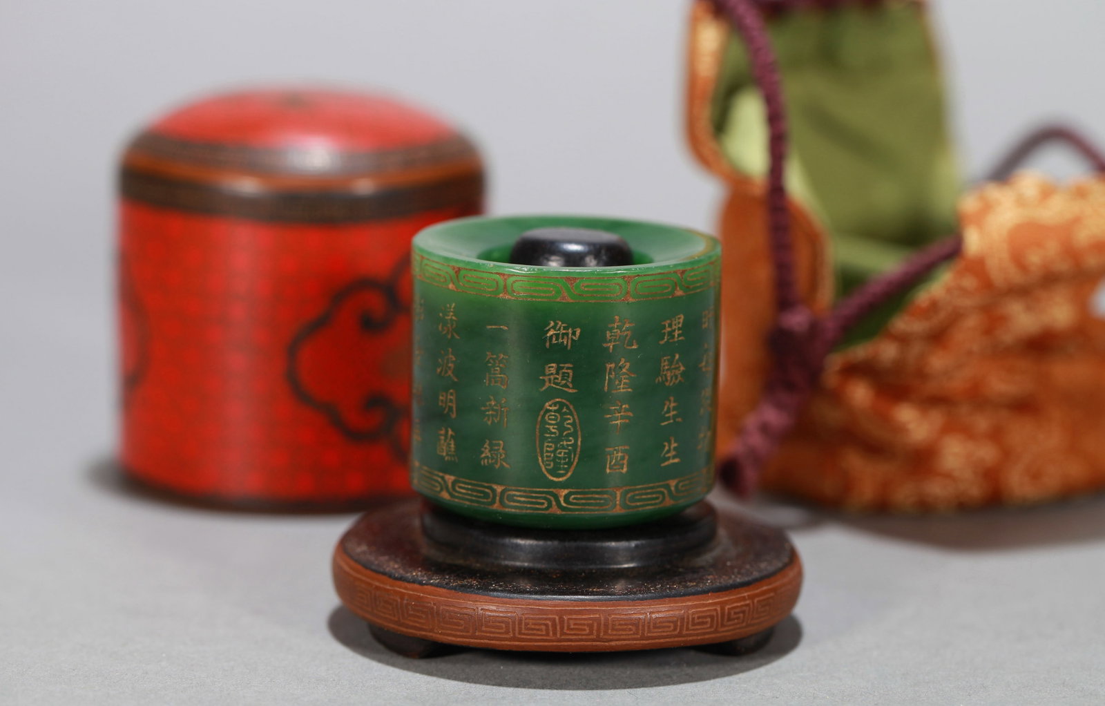 A SPINACH GREEN JADE 'POETRY' THUMB RING: A SPINACH GREEN JADE 'POETRY' THUMB RING Dimensions: Length: 4 cm (1.57 in.), Width: 4 cm (1.57 in.), Height: 3.5 cm (1.38 in.). All measurements are approximate.