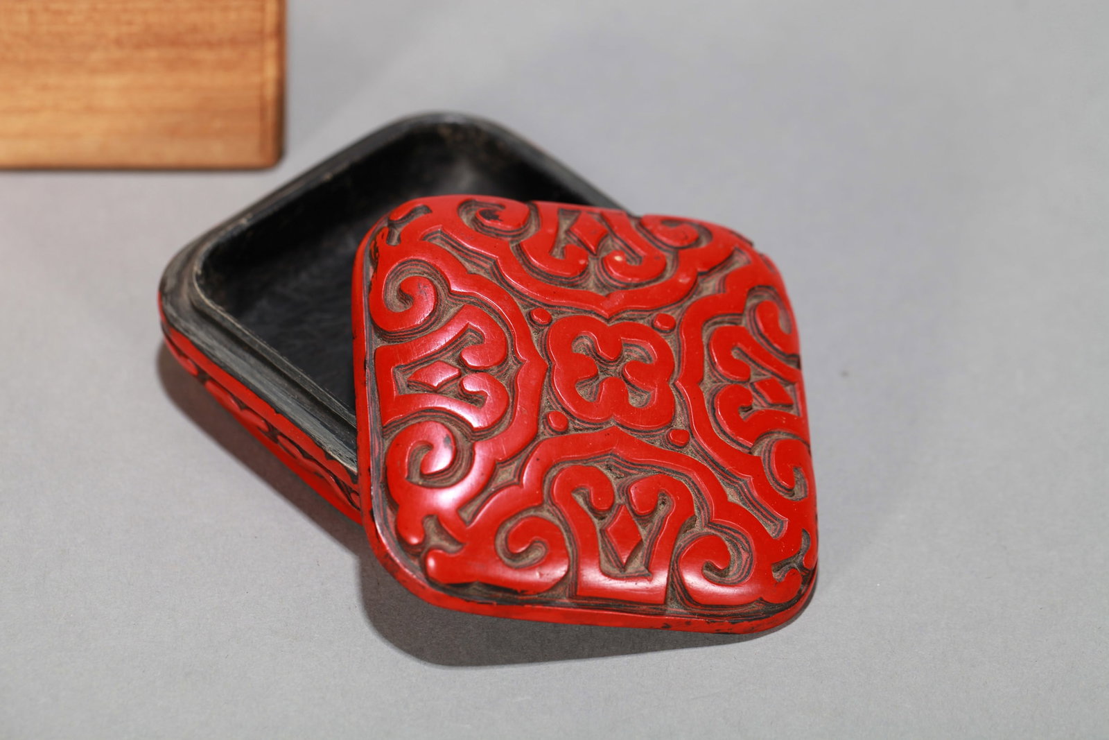 A CARVED RED LACQUER 'FLOWERS' COVERED BOX: A CARVED RED LACQUER 'FLOWERS' COVERED BOX Dimensions: Length: 7 cm (2.76 in.), Width: 7 cm (2.76 in.), Height: 3 cm (1.18 in.). All measurements are approximate.