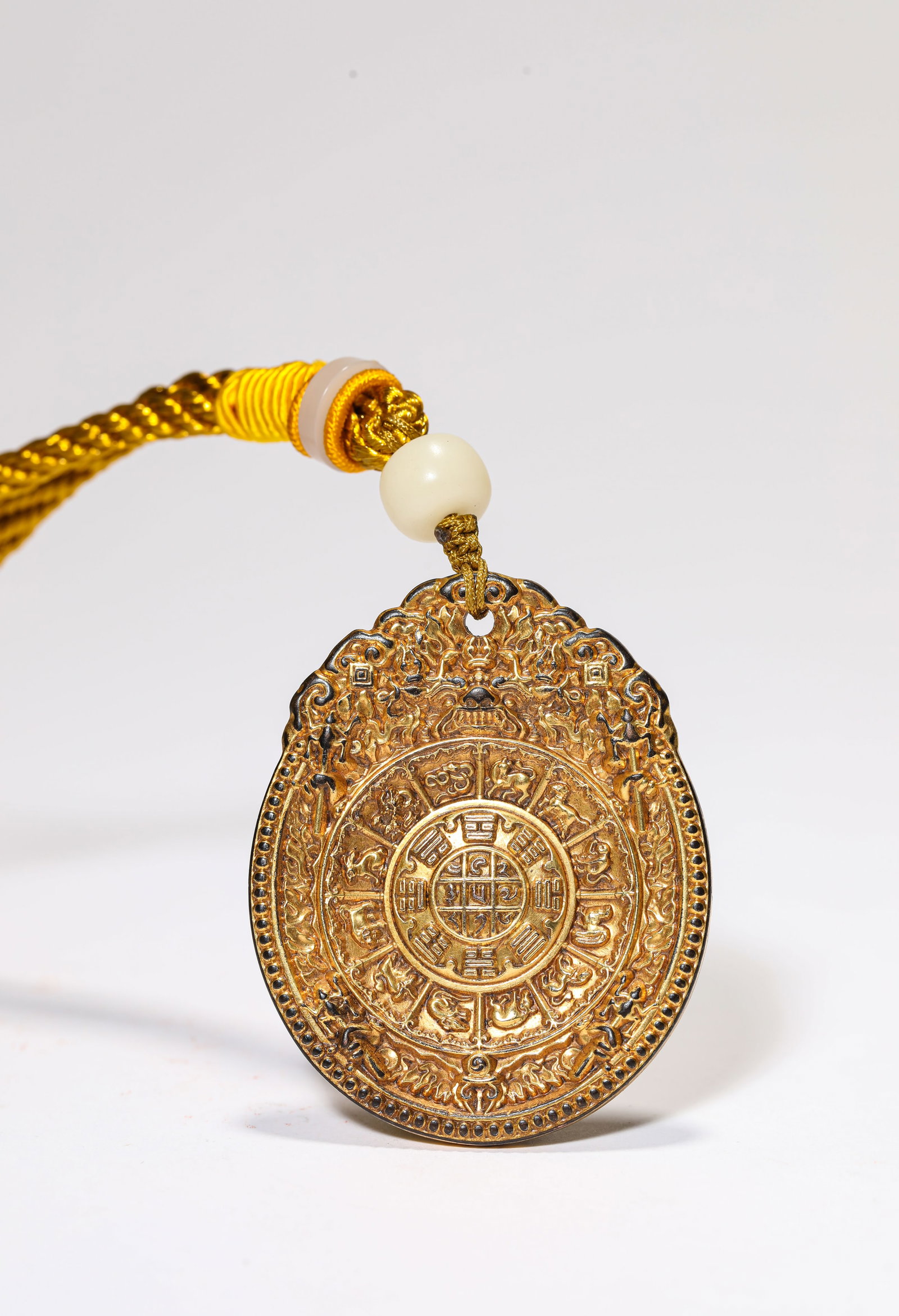 A GILT DECORATED-BRONZE 'EIGHT TRIGRAMS' PLAQUE: A GILT DECORATED-BRONZE 'EIGHT TRIGRAMS' PLAQUE Dimensions: Width: 4.3 cm (1.69 in.), Height: 5.4 cm (2.13 in.). Weight: 52 g. All measurements are approximate.