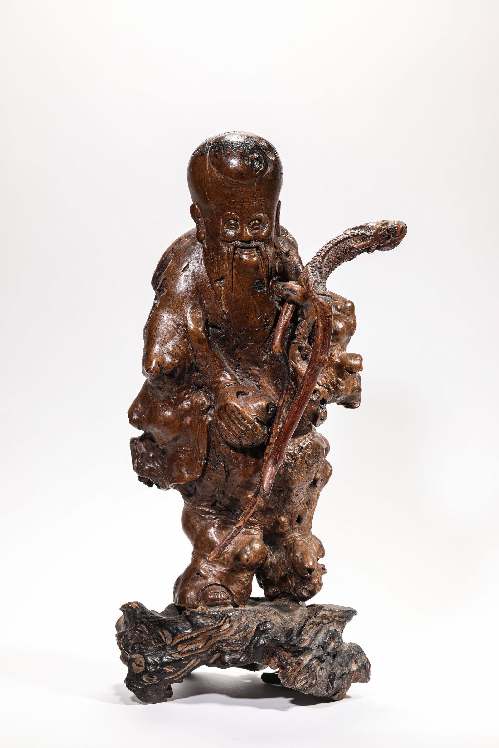 A WOOD CARVED 'SHOU XING' FIGURE: A WOOD CARVED 'SHOU XING' FIGURE Dimensions: Length: 21 cm (8.27 in.), Width: 12 cm (4.72 in.), Height: 45 cm (17.72 in.). All measurements are approximate.