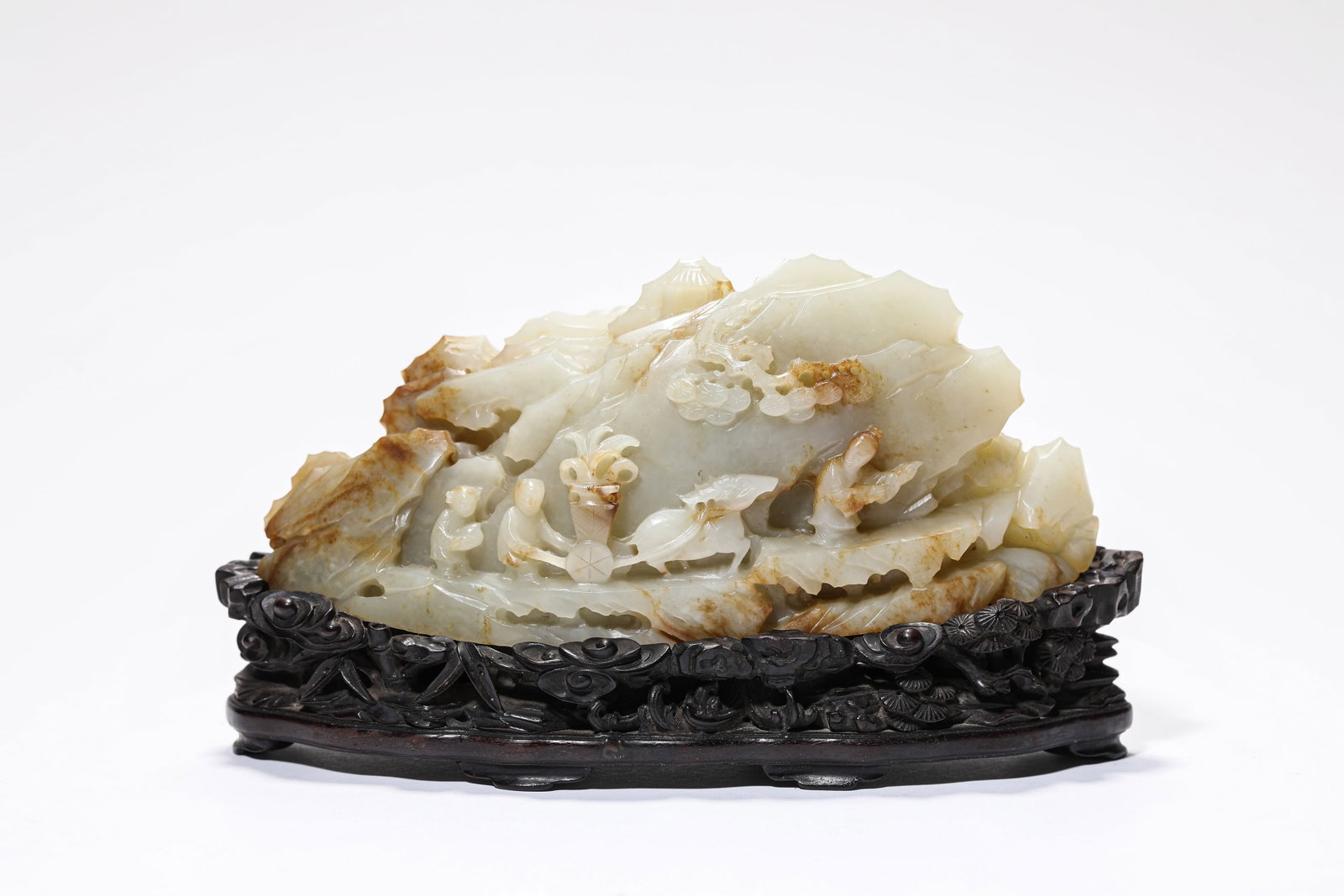 A JADE CARVED 'FIGURES AND STORY' MOUNTAIN-FORM ORNAMENT: A JADE CARVED 'FIGURES AND STORY' MOUNTAIN-FORM ORNAMENT Dimensions: Length: 16.3 cm (6.42 in.), Width: 4.9 cm (1.93 in.), Height: 6.4 cm (2.52 in.). All measurements are approximate.