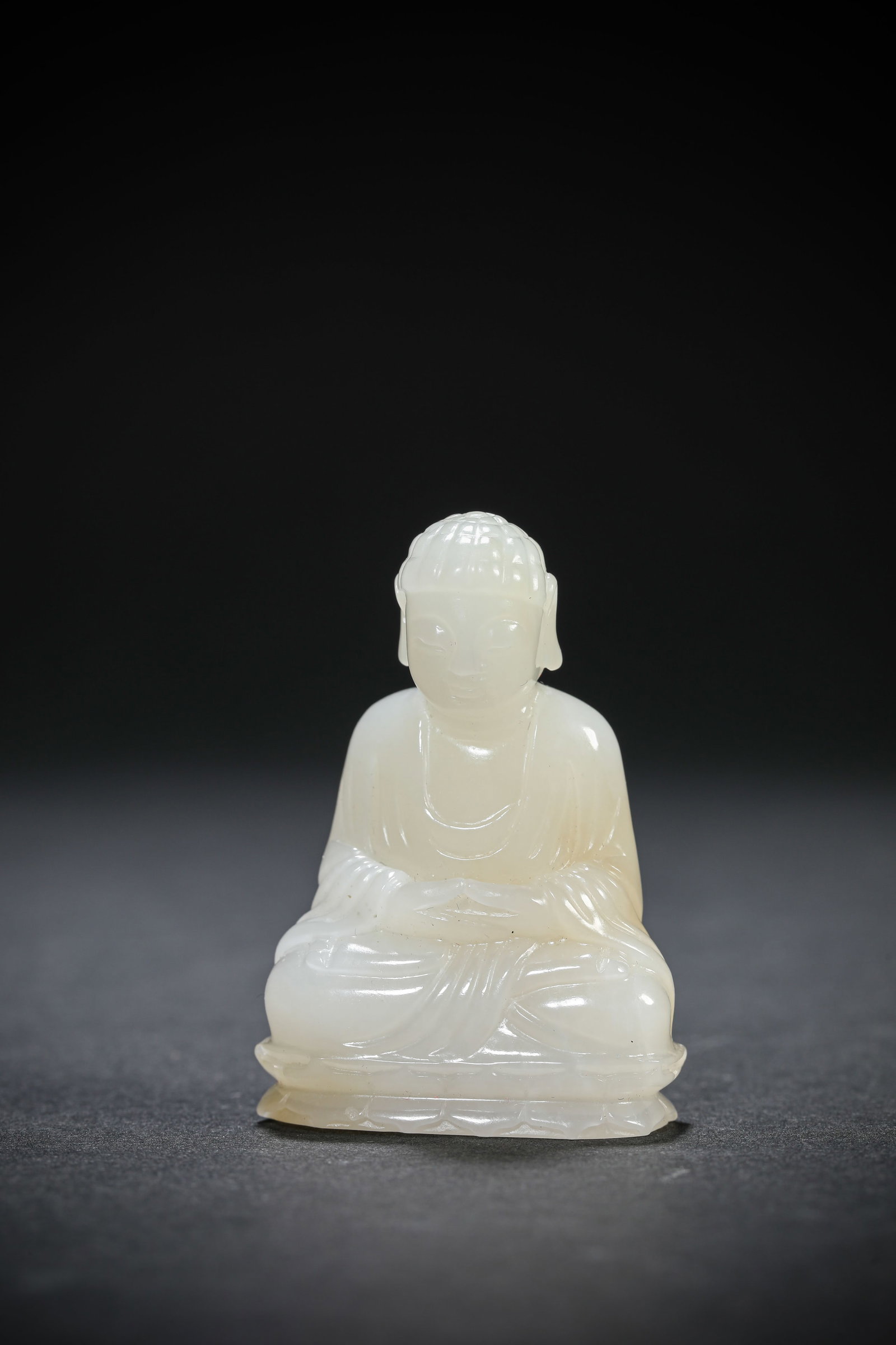 A JADE FIGURE OF SAKYAMUNI: A JADE FIGURE OF SAKYAMUNI Dimensions: Length: 3.3 cm (1.30 in.), Width: 1.8 cm (0.71 in.), Height: 4.8 cm (1.89 in.). All measurements are approximate.
