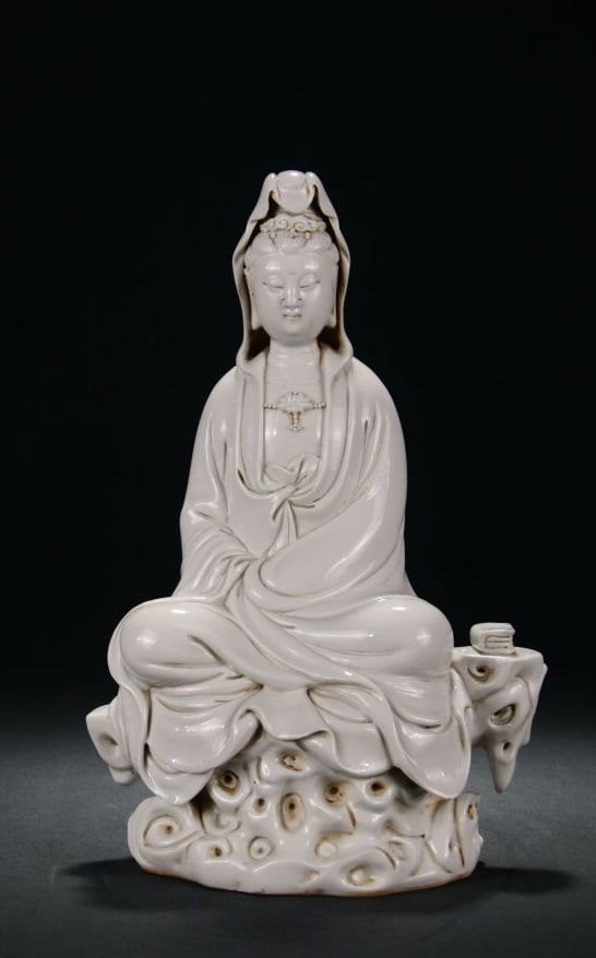 A DEHUA WHITE PORCELAIN SEATED GUANYIN ON ROCK: A DEHUA WHITE PORCELAIN SEATED GUANYIN ON ROCK Dimensions: Height: 34 cm (13.39 in.), Width: 23 cm (9.06 in.). All measurements are approximate.