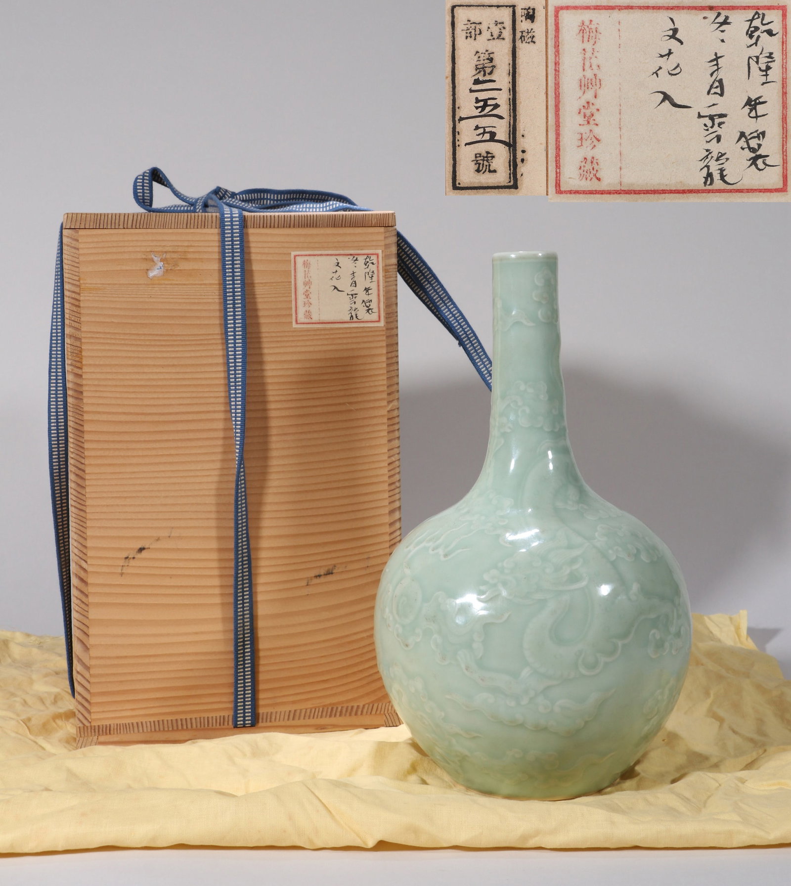 A CELADON MOULDED 'CLOUD AND DRAGON' LONG-NECK VASE: A CELADON MOULDED 'CLOUD AND DRAGON' LONG-NECK VASE From the Meihua Cottage Collection of Chinese Art Dimensions: Height: 27 cm (10.63 in.). All measurements are approximate.