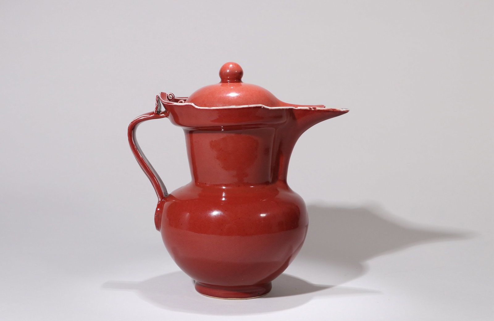 A RUBY RED-GLAZED 'PLAIN' MONK'S-CAP EWER: A RUBY RED-GLAZED 'PLAIN' MONK'S-CAP EWER Dimensions: Length: 23 cm (9.06 in.), Height: 24 cm (9.45 in.). All measurements are approximate.