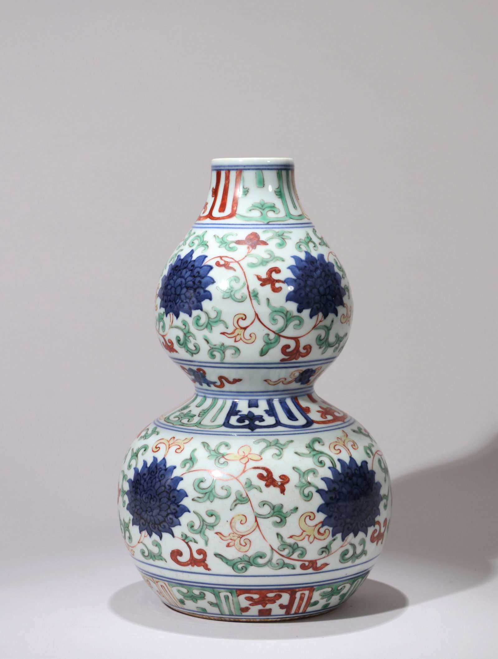 A BLUE AND WHITE AND WUCAI 'FLOWERS' GOURD VASE: A BLUE AND WHITE AND WUCAI 'FLOWERS' GOURD VASE Dimensions: Height: 25 cm (9.84 in.). All measurements are approximate.