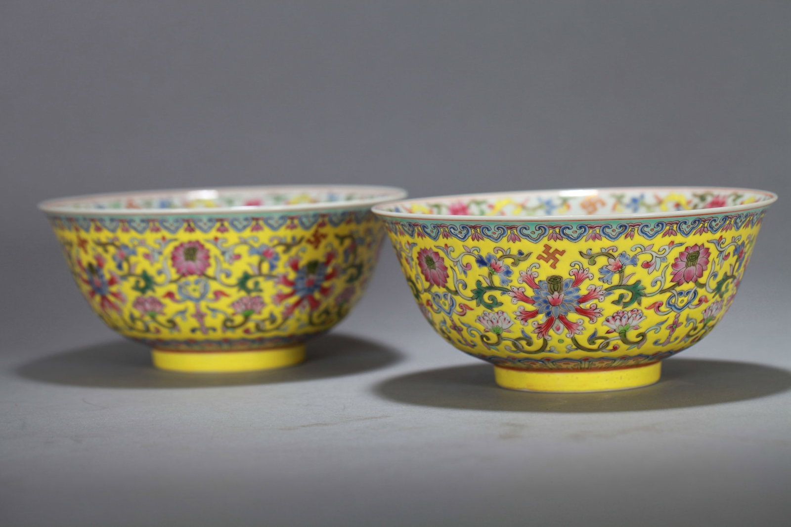 A PAIR OF YELLOW-GROUND FAMILLE ROSE 'FLOWERS' BOWLS: A PAIR OF YELLOW-GROUND FAMILLE ROSE 'FLOWERS' BOWLS Dimensions: Length: 16 cm (6.30 in.), Width: 16 cm (6.30 in.), Height: 7.5 cm (2.95 in.). All measurements are approximate.