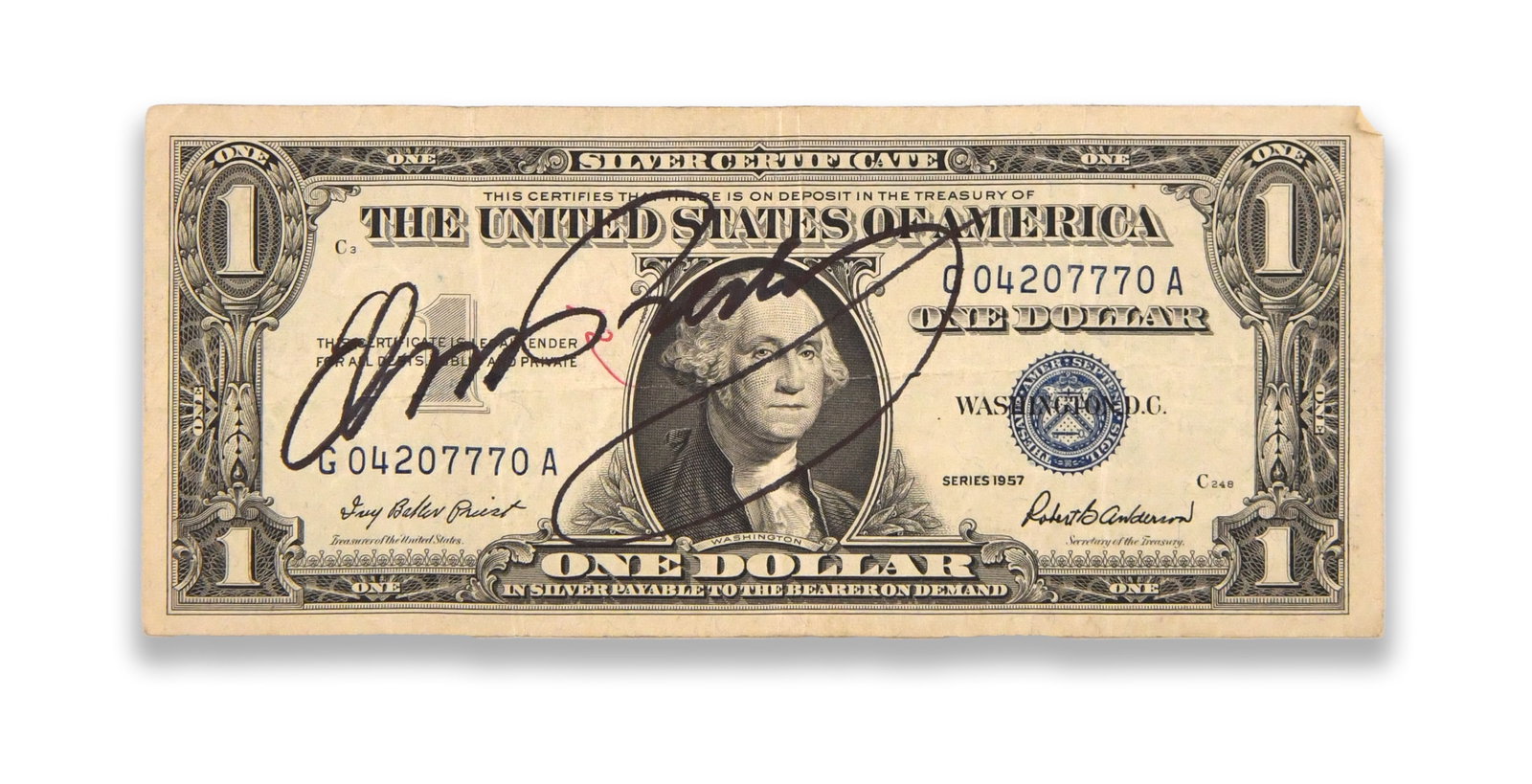 ELVIS PRESLEY - SIGNED 1957 ONE DOLLAR SILVER CERTIFICATE: ELVIS PRESLEY - SIGNED 1957 ONE DOLLAR SILVER CERTIFICATE Signature: Elvis Presley. Description: A Series 1957 United States one-dollar Silver Certificate bearing the blue Treasury seal and serial num