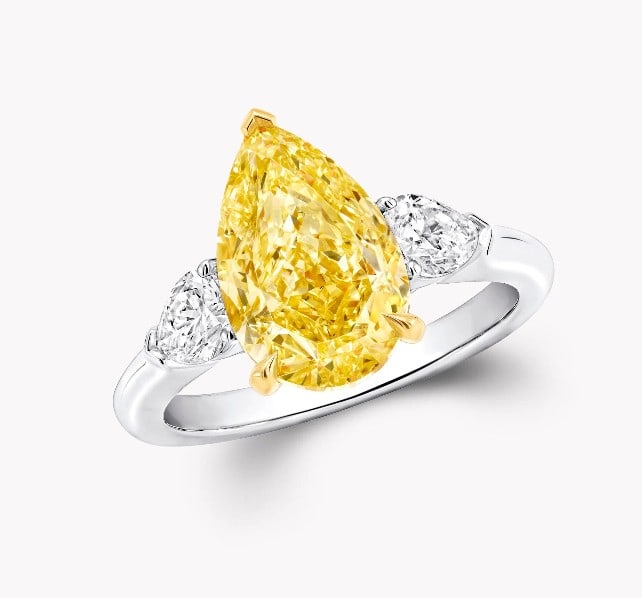 PEAR-SHAPED VIVID YELLOW DIAMOND RING: PEAR-SHAPED VIVID YELLOW DIAMOND RING Description: The pear-shaped diamonds with harmonious proportions are set in simple platinum and 18K yellow gold, flanked by pear-shaped white diamonds, creating 
