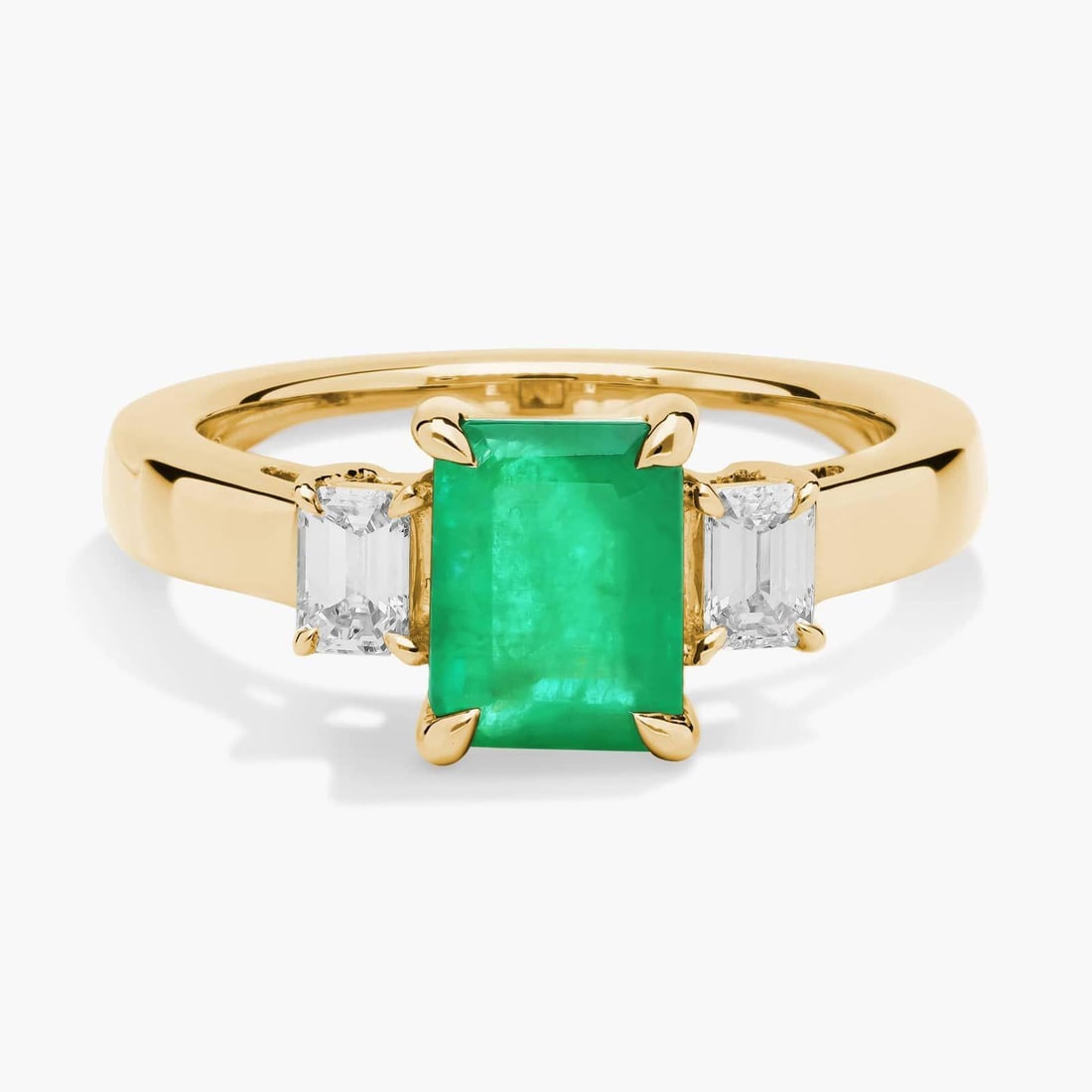 EMERALD CUT EMERALD AND DIAMOND RING IN 14K YELLOW GOLD (8X6MM): EMERALD CUT EMERALD AND DIAMOND RING IN 14K YELLOW GOLD (8X6MM) Description: A gorgeously green emerald-cut emerald takes centre stage in this stunning ring, with an emerald-cut accent diamond on eith
