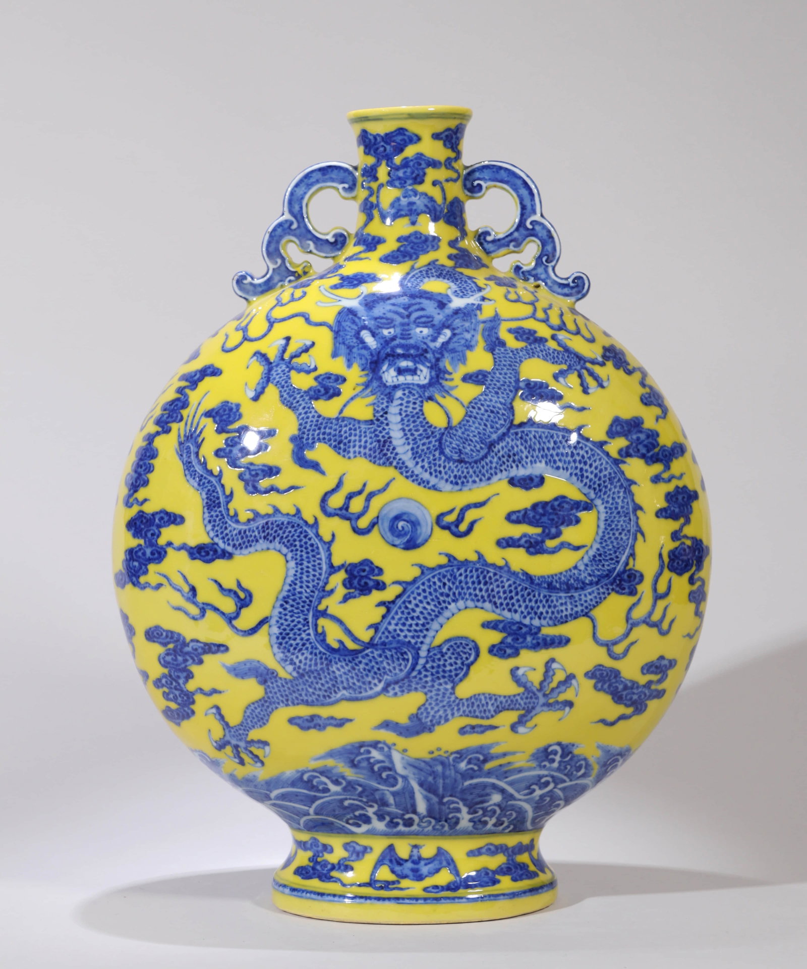 A YELLOW-GROUND BLUE AND WHITE 'WAVES AND DRAGON' FLASK: A YELLOW-GROUND BLUE AND WHITE 'WAVES AND DRAGON' FLASK Dimensions: Height: 36 cm (14.17 in.). All measurements are approximate.