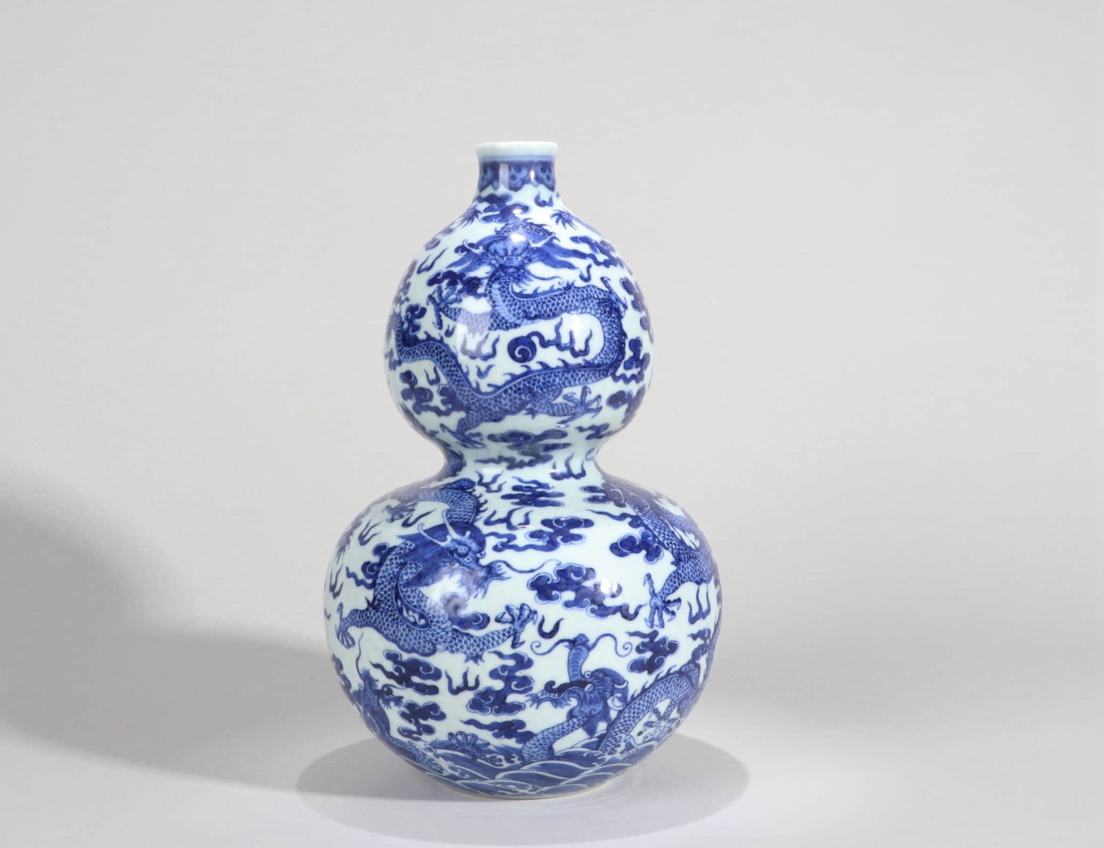 A BLUE AND WHITE 'CLOUD AND DRAGON' GOURD VASE: A BLUE AND WHITE 'CLOUD AND DRAGON' GOURD VASE Dimensions: Height: 31.5 cm (12.40 in.). All measurements are approximate.