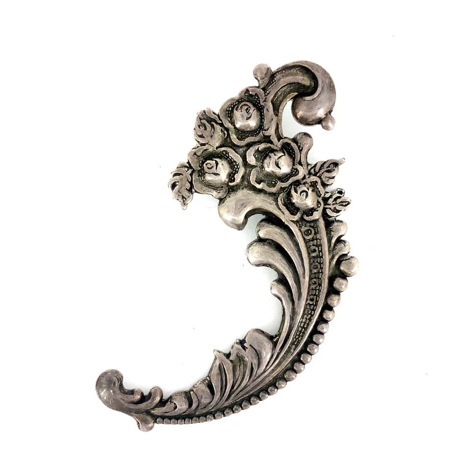 VINTAGE SILVER-TONE ROCOCO FLORAL SCROLL BROOCH: VINTAGE SILVER-TONE ROCOCO FLORAL SCROLL BROOCH Provenance and Authenticity: This object is presented as a vintage silver-tone brooch featuring an asymmetrical arrangement of sculpted flowers, leaves,