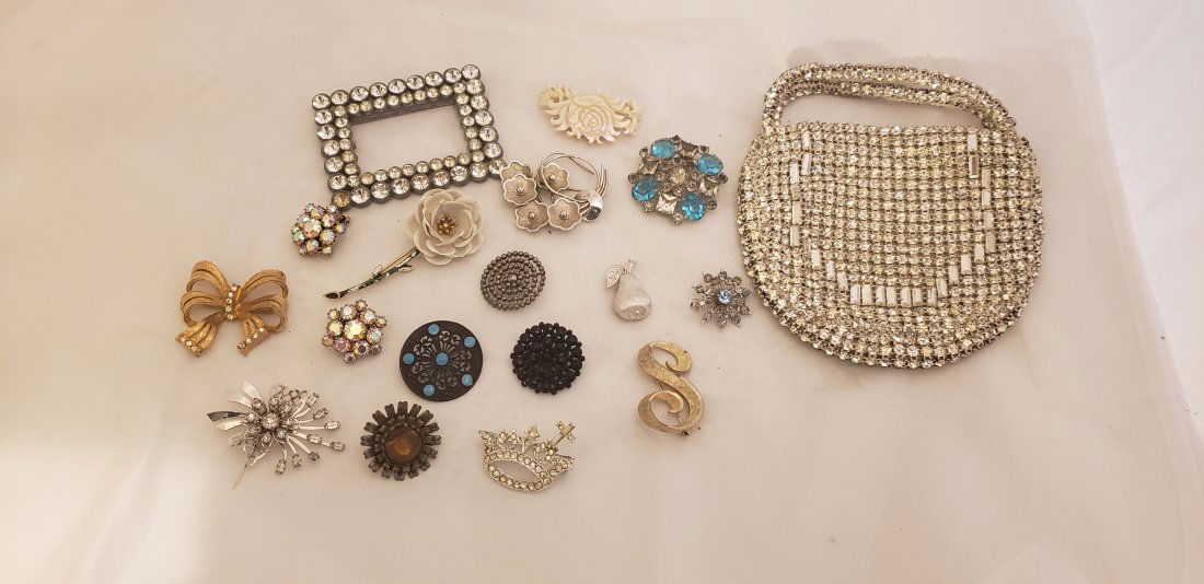 Antique Buttons and mixed Costume Jewelry lot: Antique Buttons and mixed Costume Jewelry lot. Very old decorative Buttons, a rhinestone purse, pair of rhinestone clip earrings and some nice brooches including a Crown Trifari piece. Buyers Premium