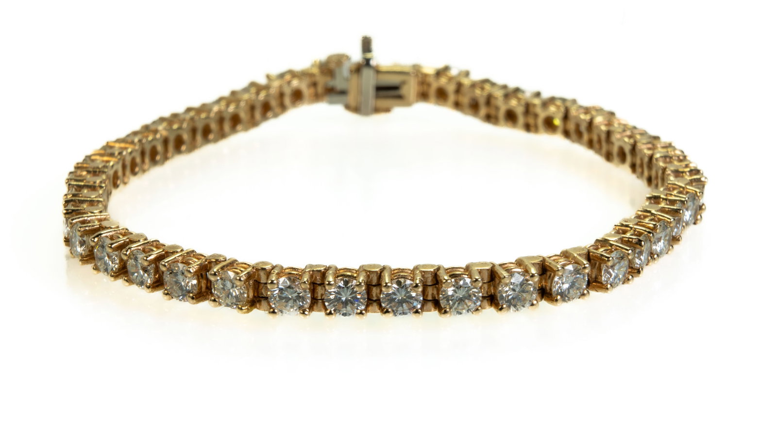 14k Yellow Gold Diamond Tennis Bracelet: 14k yellow gold and diamond tennis bracelet comprised of 40 bead set round cut diamonds (estimated at 0.13 ct. each, estimated total weight: 5.2 ct.). Measurements: Bracelet is 6 3/4 inches long (17 c