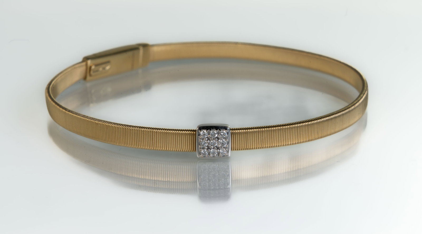 Marco Bicego 18k Yellow Gold and Diamond Masai Bracelet: 18k Marco Bicego Masai yellow gold medium single strand stackable bracelet with small square pave diamond set in white gold. The bracelet is made of a single strand of flat spiral threads, created usi