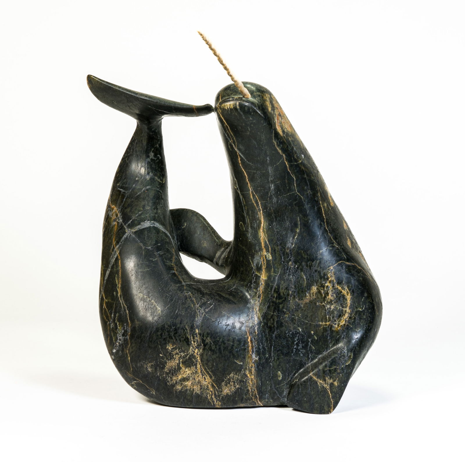 Inuit Stone Sculpture of a Narwhal: Inuit stone carving of a Narwahl. No signature found. Sculpture measures 12 in. (not including removable bone tusk) x 4 x 10 in.