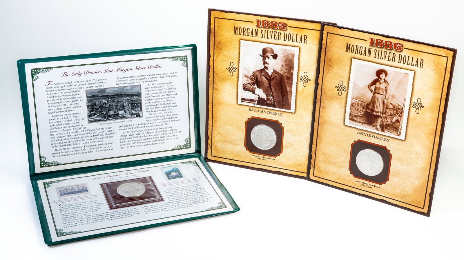 Three (3) Morgan Silver Dollars Uncirculated: Three (3) Morgan silver dollars, including: 1882 S with a Bat Masterson stamp 1886 with an Annie Oakley stamp 1921 D Postal Commemorative Society with 2 stamps.