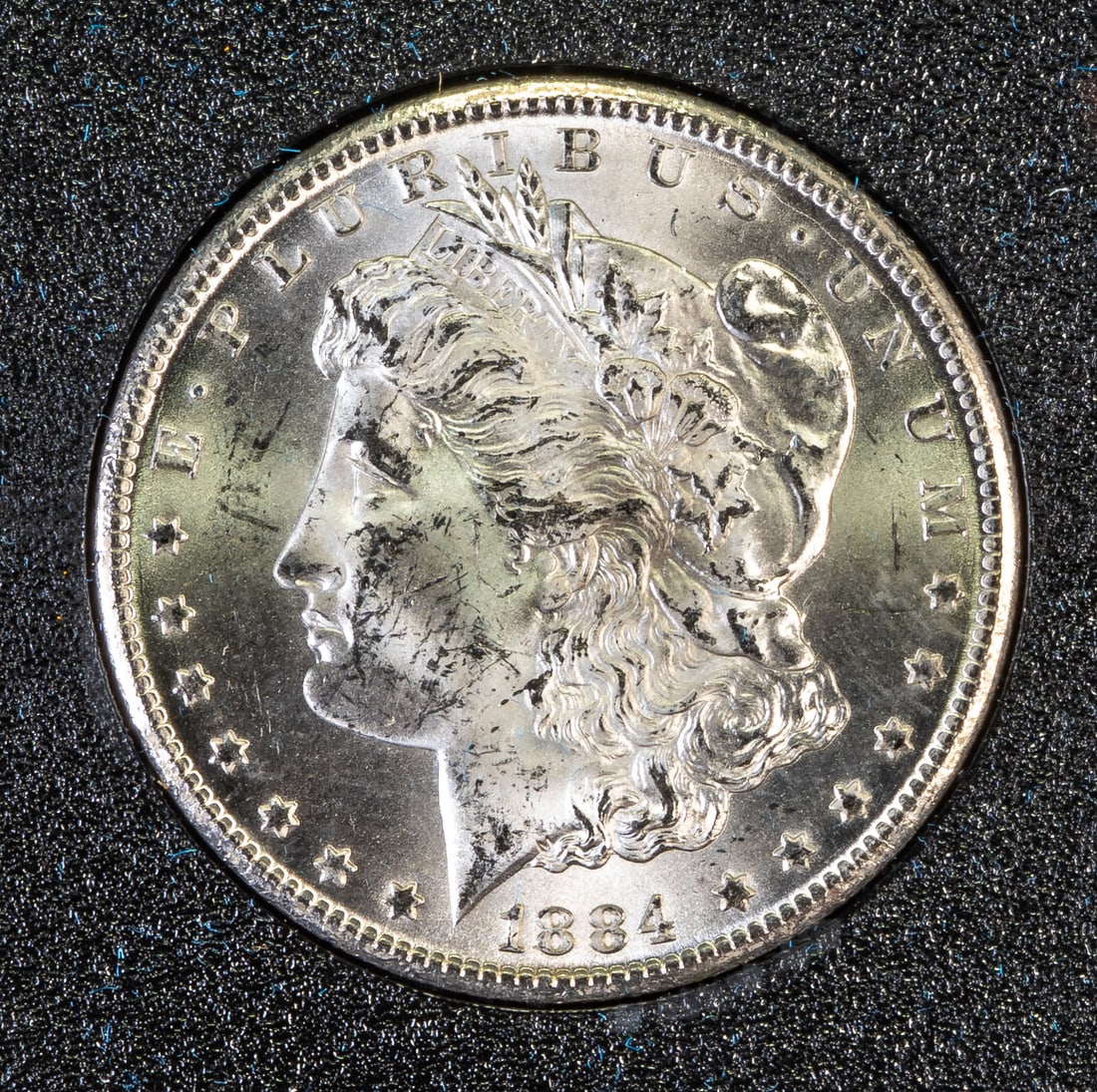 1884 Morgan Carson City Silver Dollar Uncirculated: An 1884 Uncirculated Morgan Carson City Silver Dollar, with original box and paper.