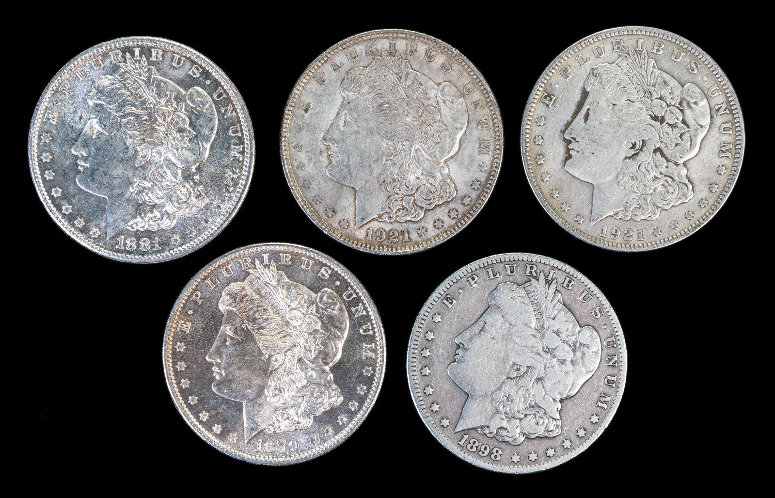 Five (5) Morgan Silver Dollars: Five (5) Morgan silver dollars, 90% silver. Years: 1879 S, 1881 S, 1898 S, two (2) 1921.