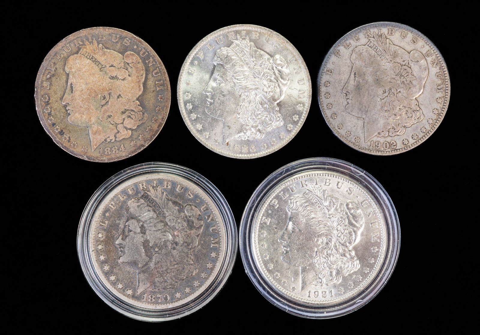 Five (5) Morgan Silver Dollars: Five (5) Morgan silver dollars. Years: 1879 O, 1884, 1886 O, 1902 O, 1921 S.
