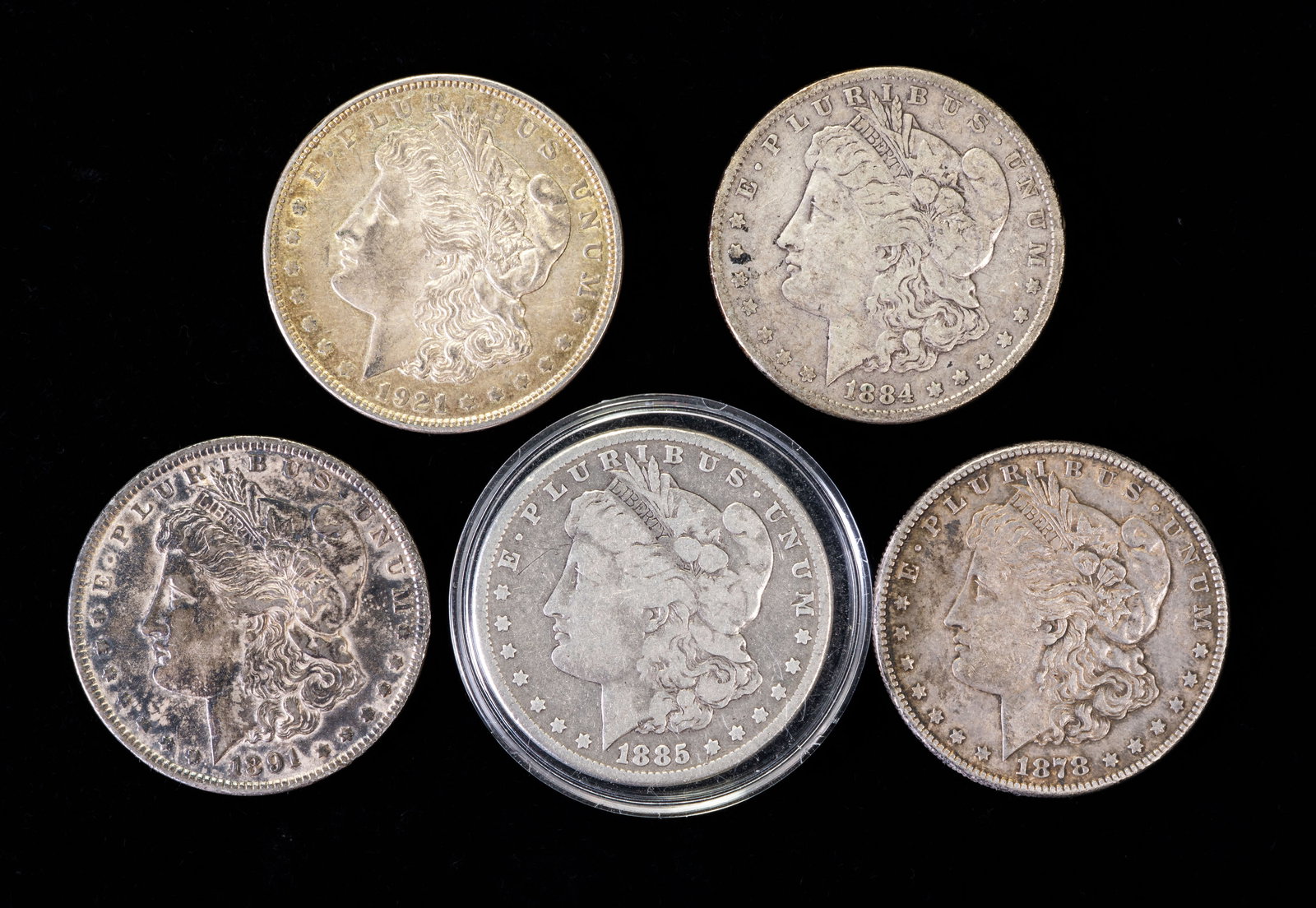 Five (5) Morgan Silver Dollars: Five (5) Morgan silver dollars. Years: 1878 S, 1884, 1885, 1891, 1931 D.