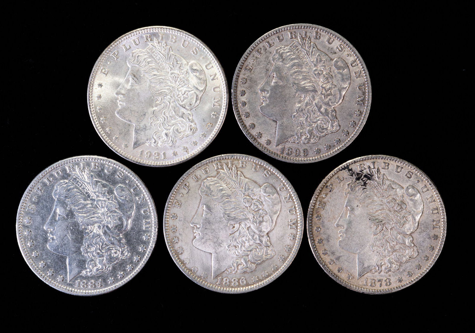 Five (5) Morgan Silver Dollars: Five (5) Morgan silver dollars. Years: 1878 S, 1884, 1899 O, 1886, 1921.