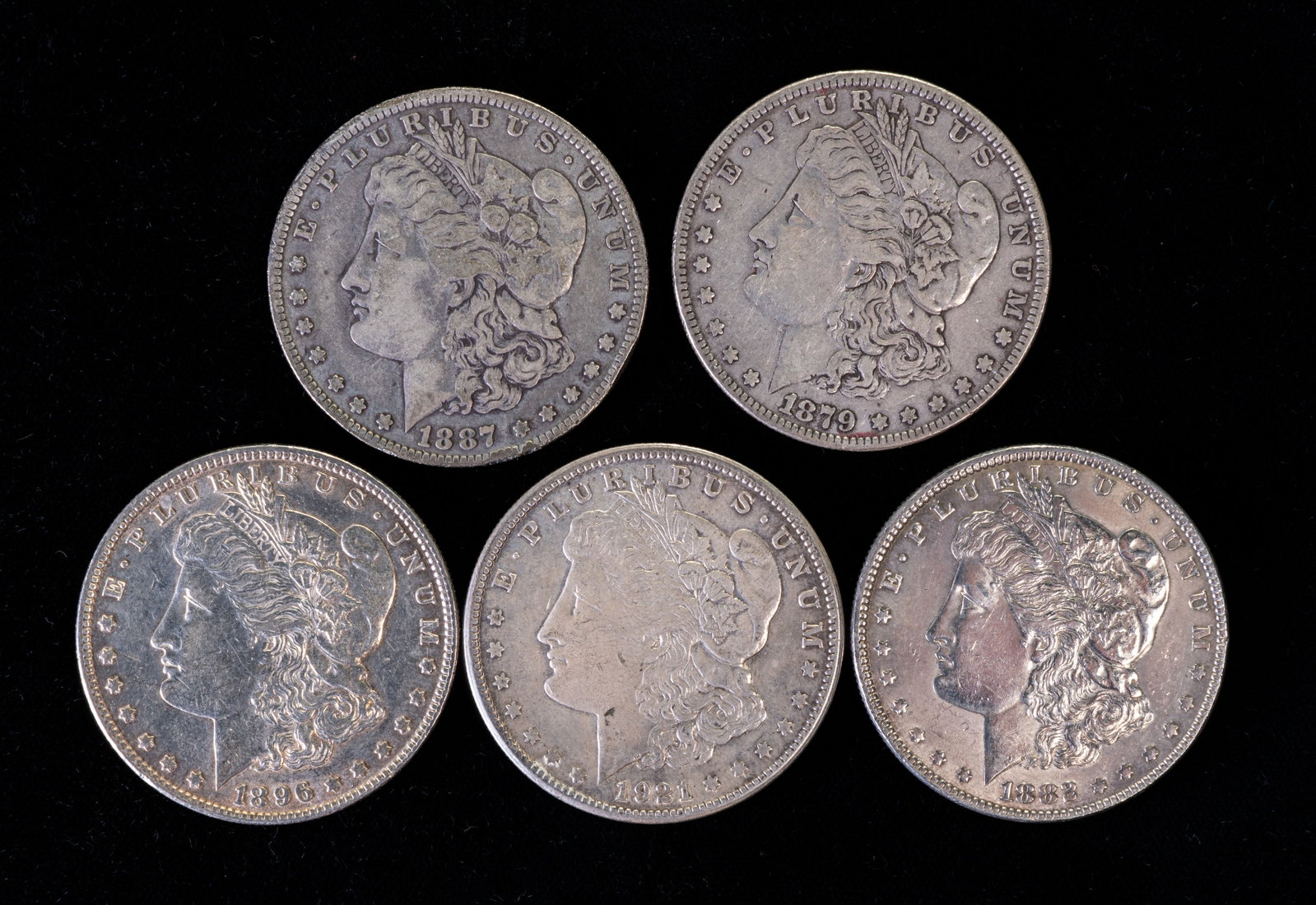 Five (5) Morgan Silver Dollars: Five (5) Morgan silver dollars. Years: 1879, 1883, 1887 O, 1896, 1921 S.
