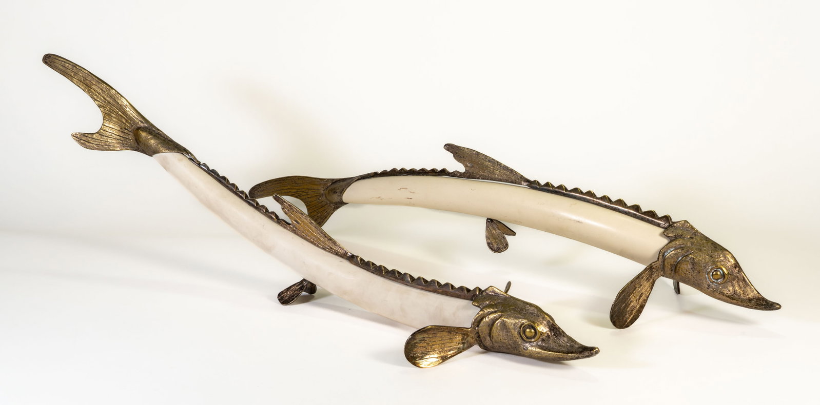 Two (2) Franco Lapini Fish Sculptures: Two (2) brass and faux alabaster Franco Lapini fish sculptures. Each sculpture signed Franco Lapini on the lower brass fin. Measurements: 26 in. long.