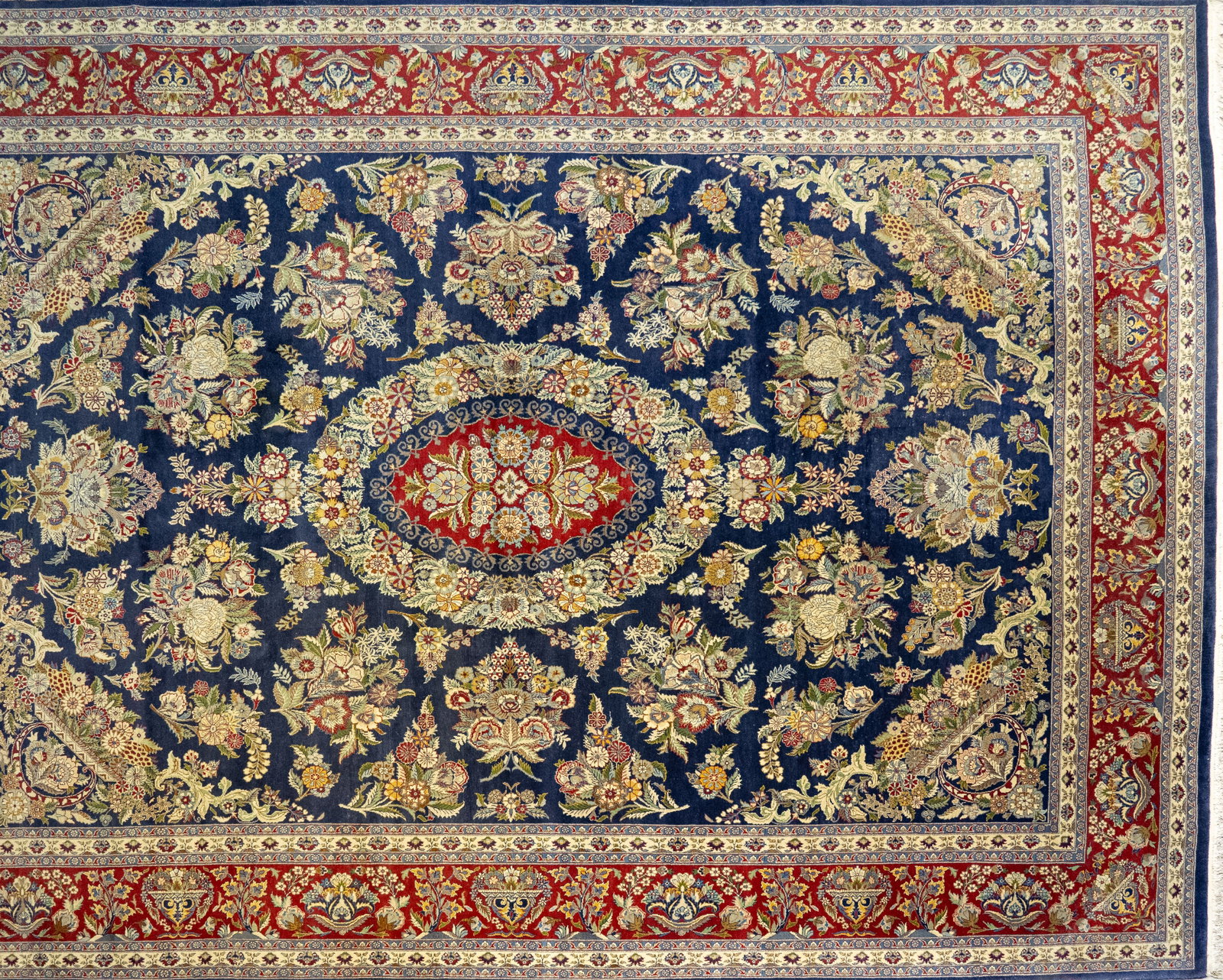 Persian Style Rug 10 ft. x 14 ft.: 20th C Pakistan hand knotted Persian-style rug. Cobalt ground with allover stylized flower and leaf motif. Wide red ground border with conforming motif. 10 feet 1 in. x 14 feet 2 in..