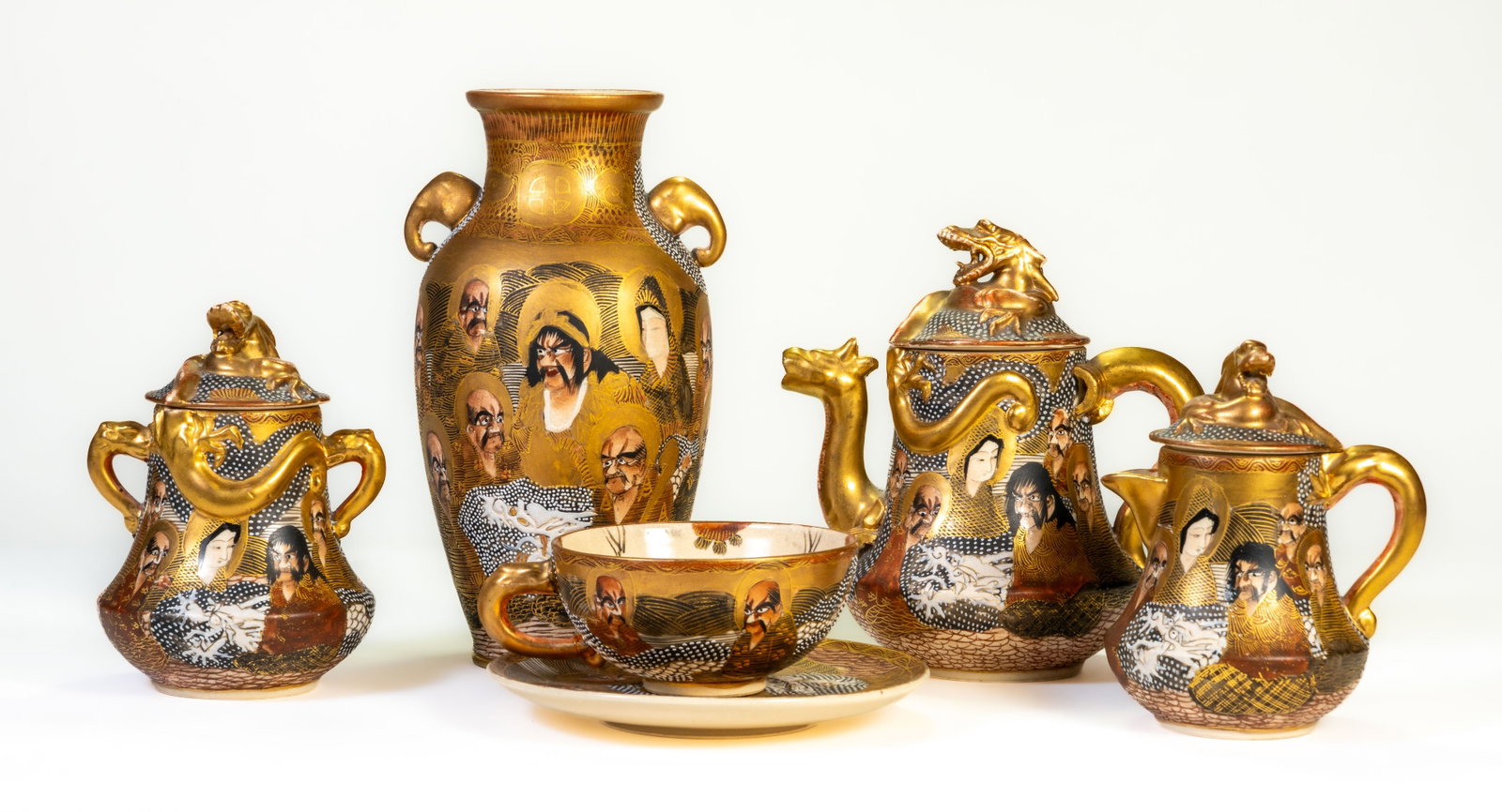 Japanese Satsuma Tea Set & Vase Thousand Face: Meiji period Japanese Satsuma Thousand Faces pattern lot: tea set (pot, creamer, sugar, one cup and saucer) all with same mark; plus a vase with different mark. Largest piece is the vase at 7 inches h
