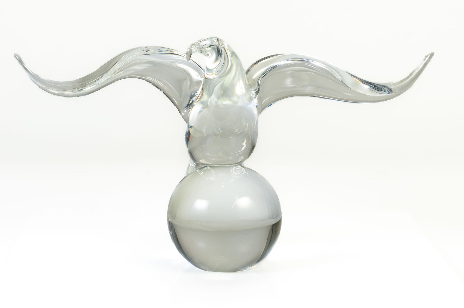 STEUBEN Crystal Eagle on Ball: Steuben spread?wing eagle perched on ball. Signed Steuben. Measures 6 3/8 in. high x 11 1/4 in. wingspan. No damage, scratches or losses. No original packaging.