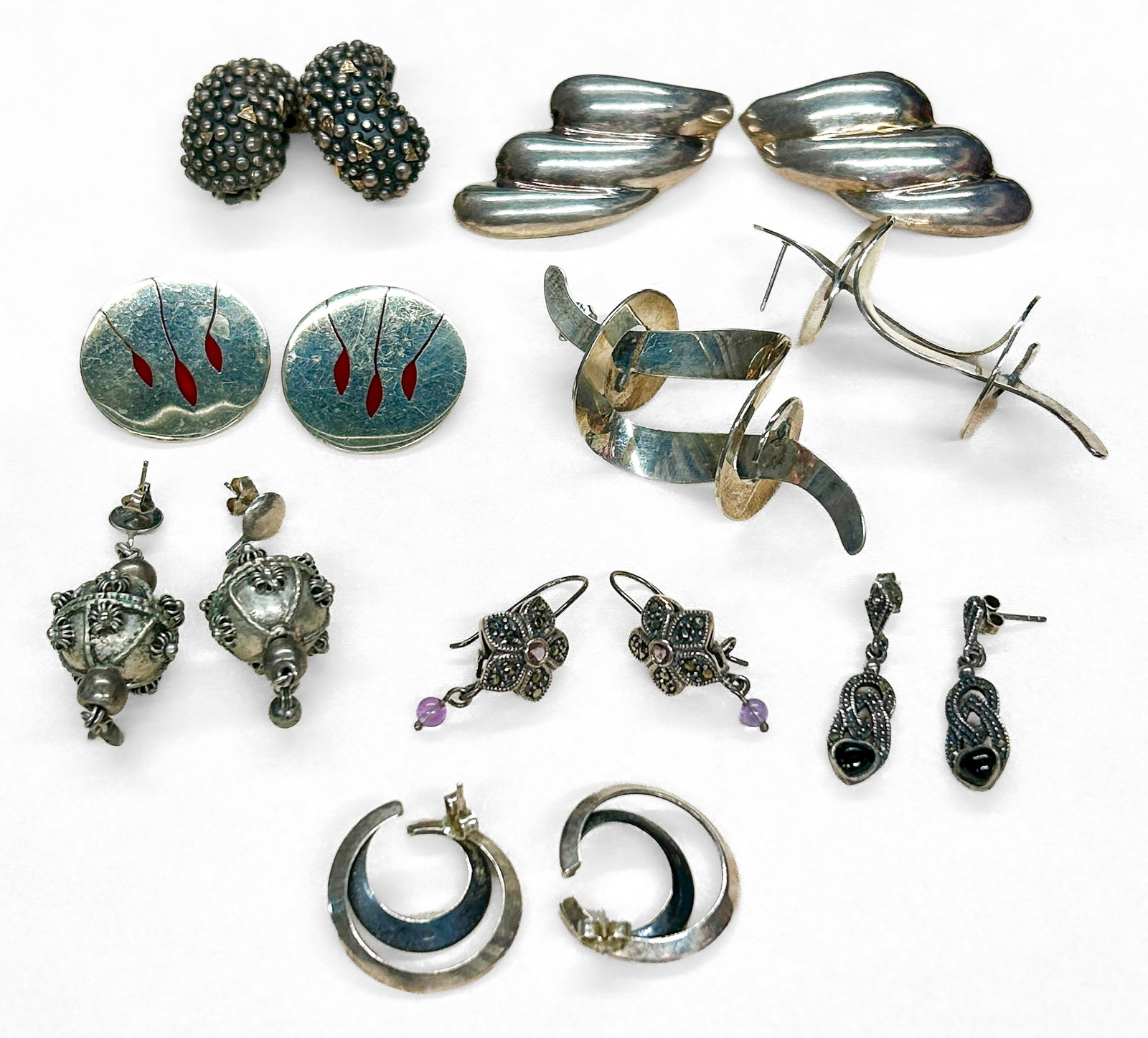 Sterling Silver Earrings: Eight (8) pairs of sterling silver earrings, all marked ?sterling? or ?925.? Some butterfly backs missing. Total weight: 3.50 ozt. Condition: No notable condition issues.
