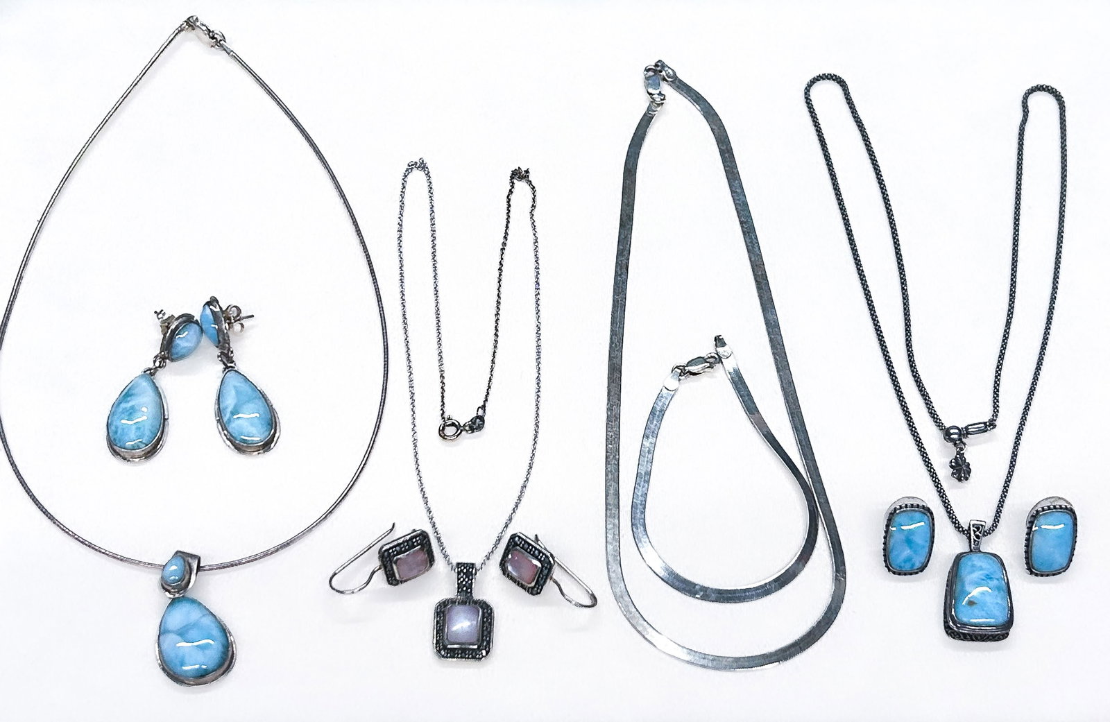 Sterling Silver Jewelry Sets: Four (4) sterling silver jewelry sets: three necklace/earring sets and one herringbone necklace/bracelet set. All marked "925". Pink stone earrings marked "Thailand". Longest necklace (blue trapezoid