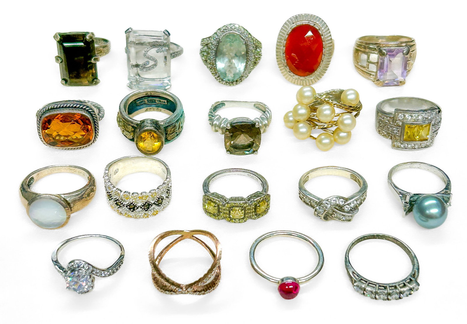 Sterling Silver Rings: Nineteen (19) sterling silver rings with semiprecious stones, pearls, and rhinestones. All marked "Sterling" and/or "925". Total Weight: 3.51 ozt. Condition: No notable condition issues. |