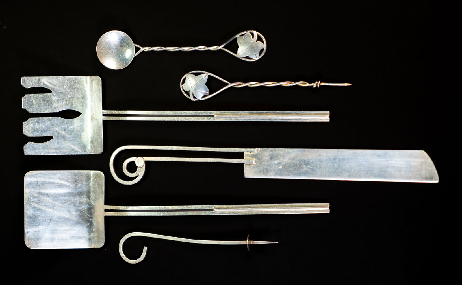Six Pieces Leonore Doskow Sterling Silver Utensils: Six pieces of Leonore Doskow handmade sterling utensils: knife (10 3/8 in.), two spatulas (9.75 in.), two nut picks, spoon. All stamped LEONORE DOSKOW HANDMADE STERLING. Total weight: 9.55 ozt. |