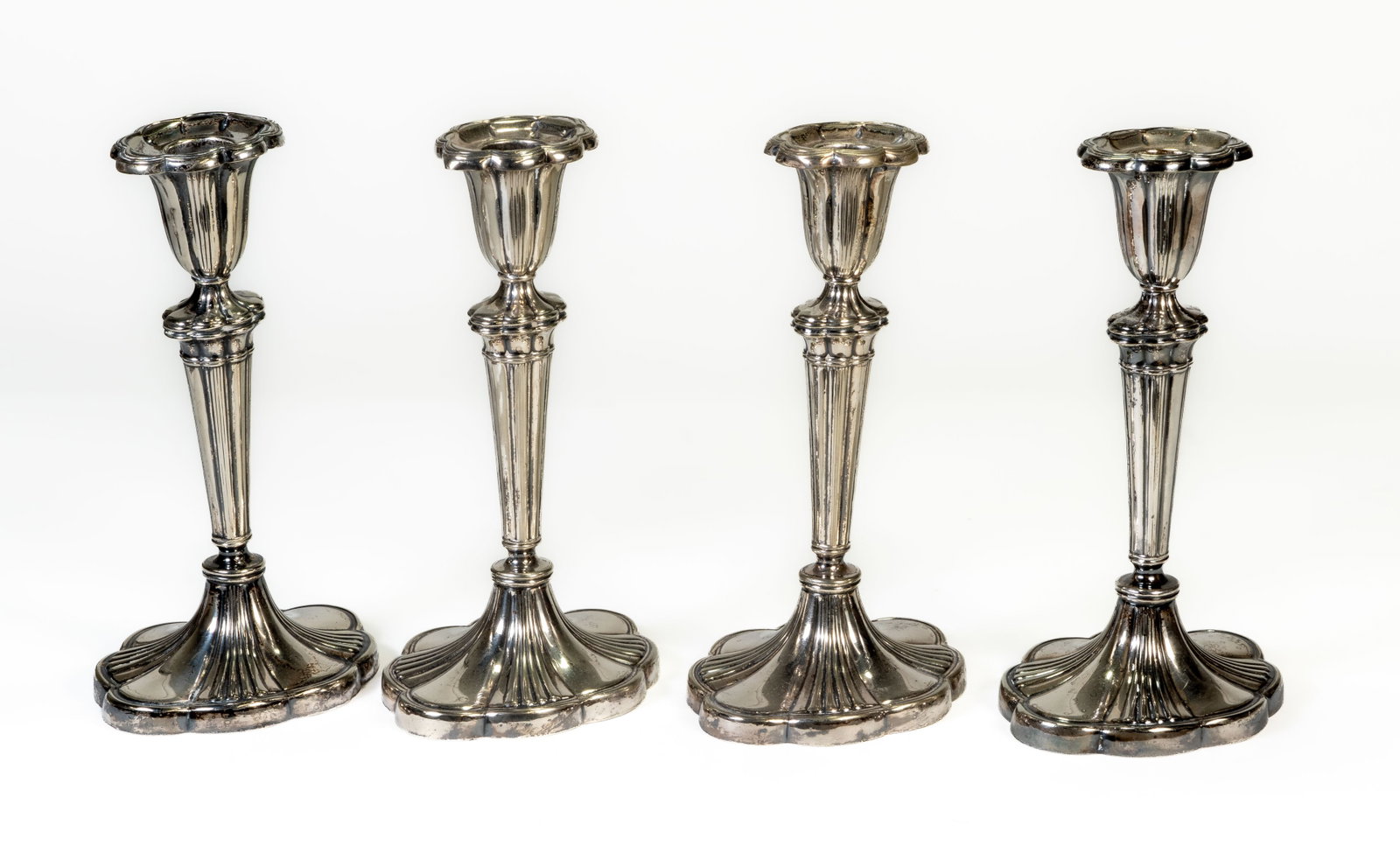 Four (4) Gorham Silverplated Candle Sticks: Matching set of four Gorham silverplated candlesticks with fluted body and shaped base. Measure 8 in. tall. |