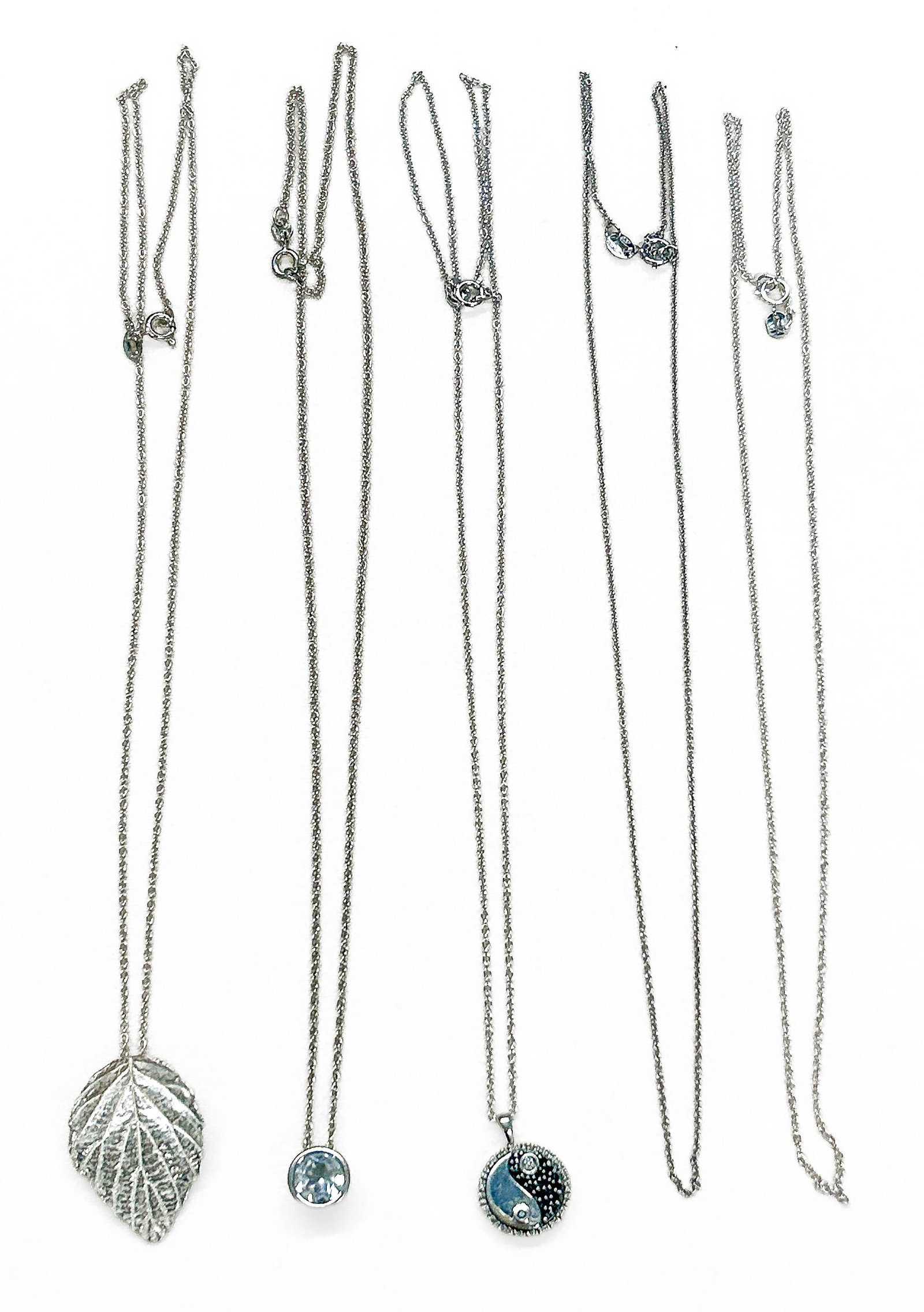 Sterling Silver Necklaces: All pendants and chains sterling silver, marked "sterling" and/or "925". Yin & Yang pendant inscribed "Harmony", marked "925, JWBR, India". White stone pendant marked "India, LJ, 925". Total Weight: