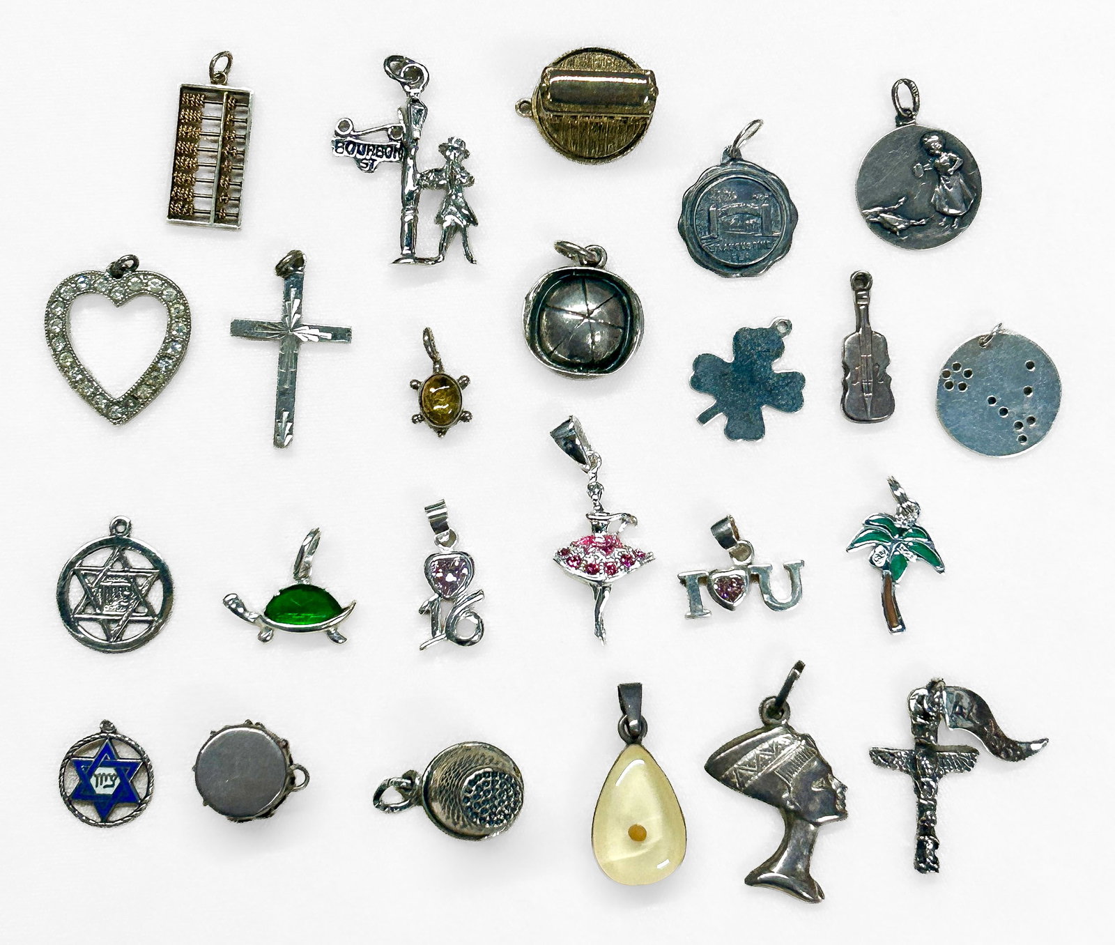 Sterling Silver Charms: Thirteen (13) sterling silver charms/pendants, all marked "925" and/or "Sterling". Total Weight: 1.36 ozt. Condition: Some tarnishing. |
