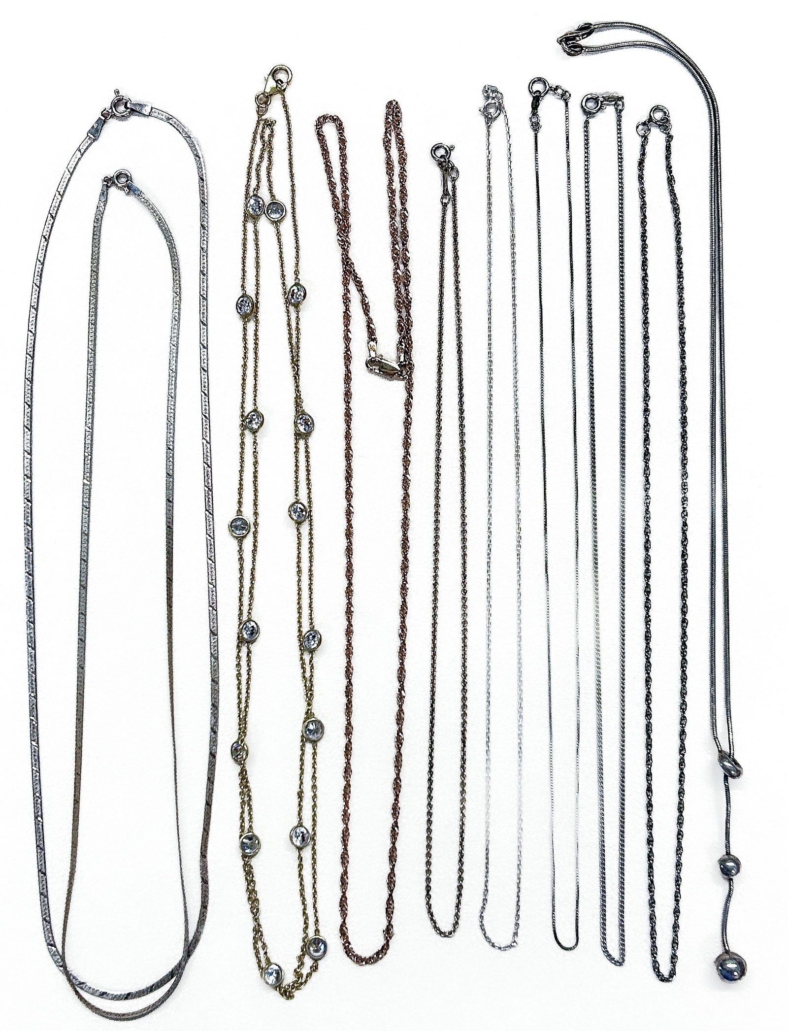 Sterling Silver Necklaces: Ten (10) chain necklaces, all marked "Sterling" or "925". Longest chain approx. 49 cm (19 in.). Total Weight: 1.25 ozt. Condition: Some tarnishing. |