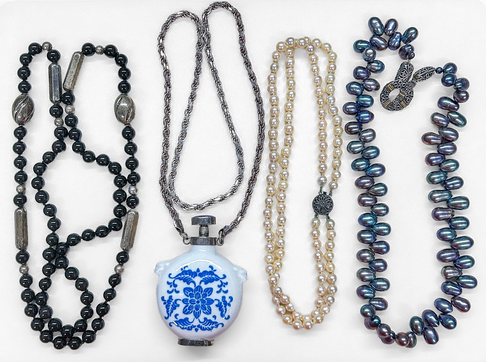 Sterling Silver & Pearl Necklaces: Four (4) sterling/pearl/bead necklaces: black glass beads with silver spacers (tested positive), ceramic perfume bottle on silver chain, double strand pearls with silver clasp, oblong peacock pearls