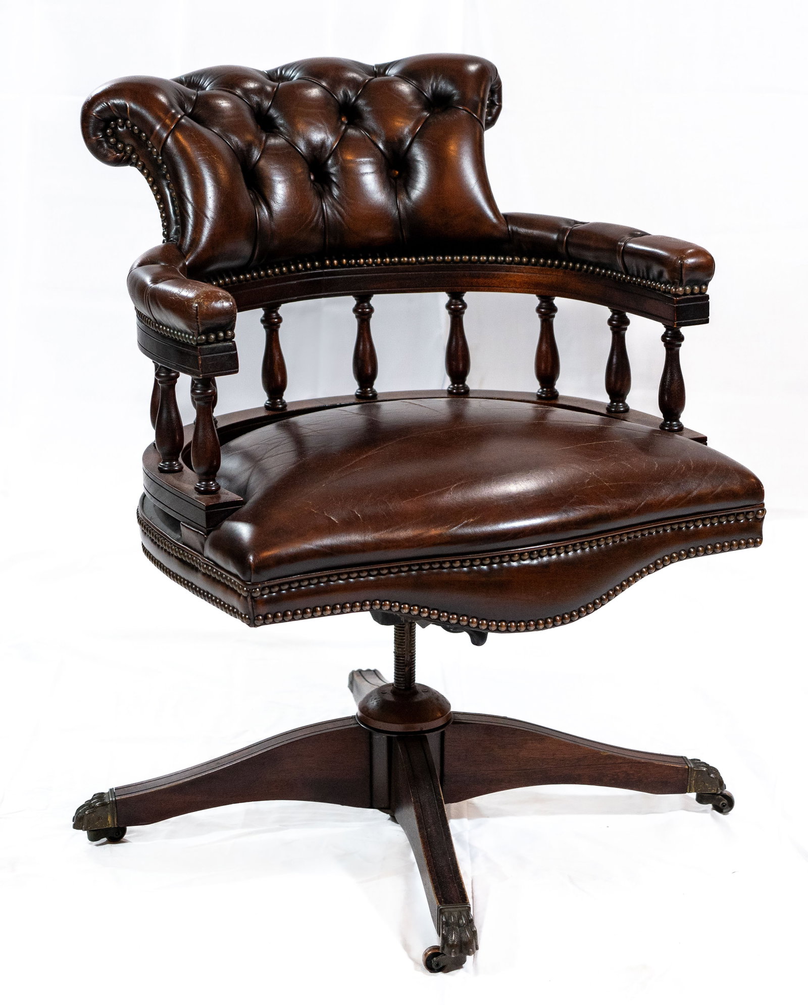 Tufted Leather Faultless Doerner Captains Chair: A dark brown leather Faultless?Doerner Captain's chair, 1960s, manufactured in Ontario, Canada. Studded crest back, studded arms above turned spindles, stuffover seat, swivel base with splayed legs te