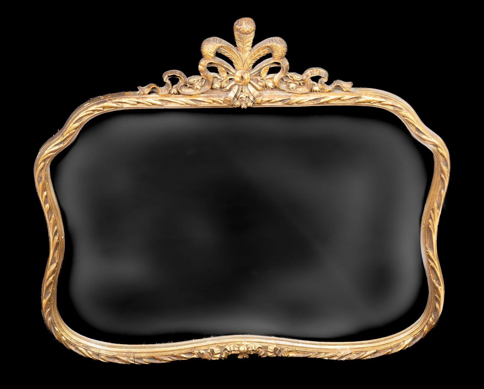 Georgian Style Giltwood Mirror: Vintage carved wood and gesso giltwood mirror. Prince of Wales feather and ribbon crest, leaf motif surround, scrolling ribbon bottom. Measures 33 in. H x 36.5 in. W. No losses; cracks in gesso.