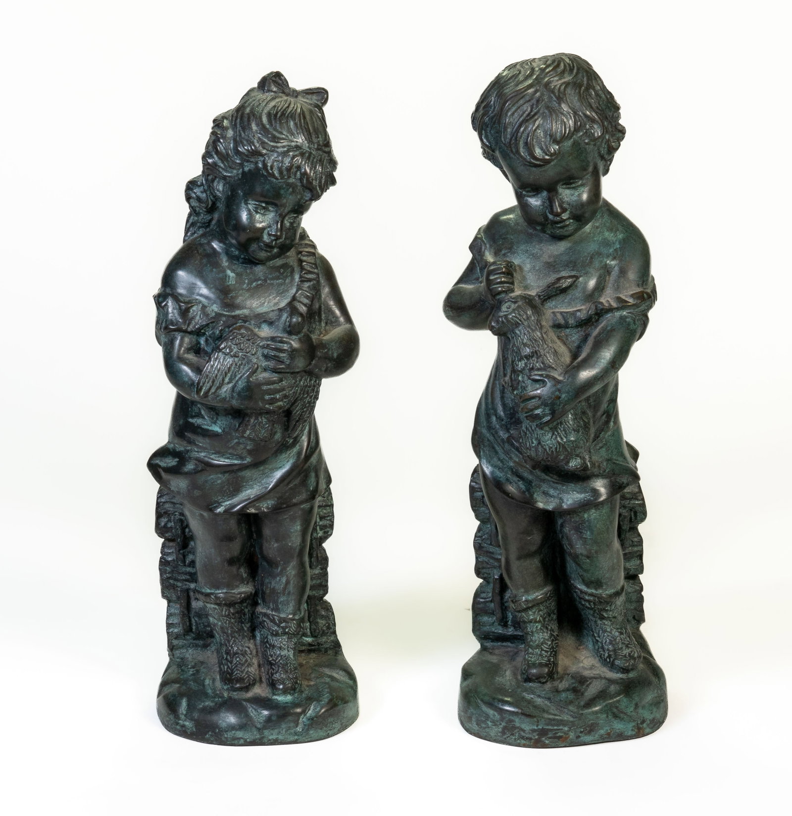 Two Maitland Smith Bronze Sculptures Boy Girl: Two Maitland Smith bronzed sculptures: young girl holding bird; young boy holding rabbit. Boy 13.5 in. tall.