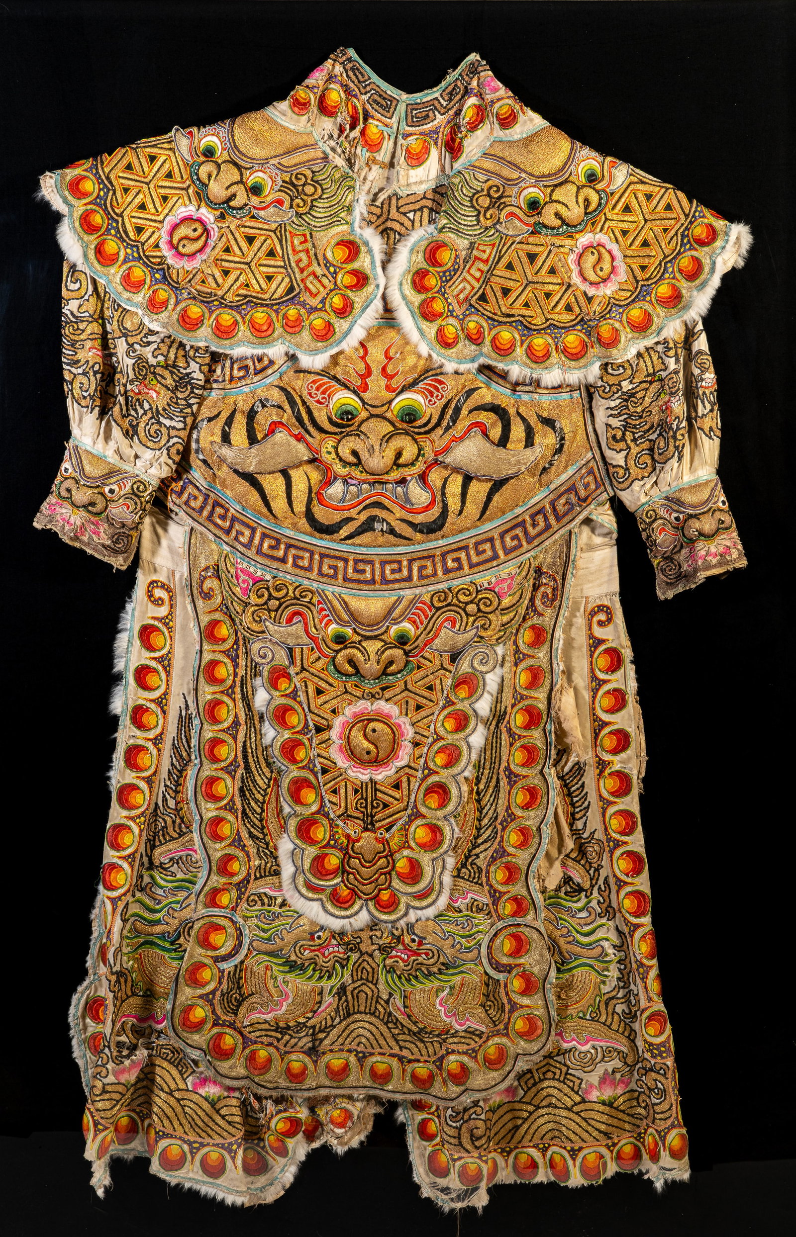 Late 19th-Century Chinese Opera Costume: Late 19th?century Chinese opera costume with elaborate embroidered Foo Lion faces and dragons. Likely deity or noble role. Measures 54 in. H x 33 in. W. Housed in plexiglass floating frame.