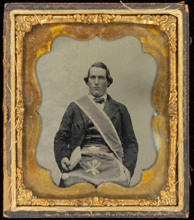 [AMBROTYPE] FRATERNITY PORTRAITS. LOT OF 4: A lot of 4 Ambrotypes sold together. Portraits of men with fraternity sashes and vestments, most tinted in gold. Includes: One (1) quarter plate ambrotype of with hat, brass frame, missing case * Thre