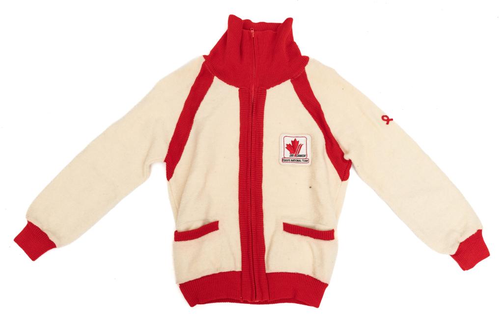 [SKIING] SKI CANADA EQUIPE NATIONAL TEAM SWEATER: SKIING. Ski Canada Equipe National Team ladies size small zip-up sweater. Demetre, White Ram Knitting Co. (Calgary). White with red collar and accents. Embroidered logo sewn on left breast. Brand logo