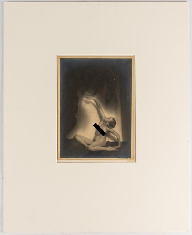 [PRINTS] KRULL, GERMAINE. SEATED NUDE. (1930): KRULL, GERMAINE. Silver print photograph of nude woman seated, reaching up to play with curtain above; possibly Berthe Krull. C. 1930 (handwritten on verso). 23 x 16.5 cm. *Additional images and detai