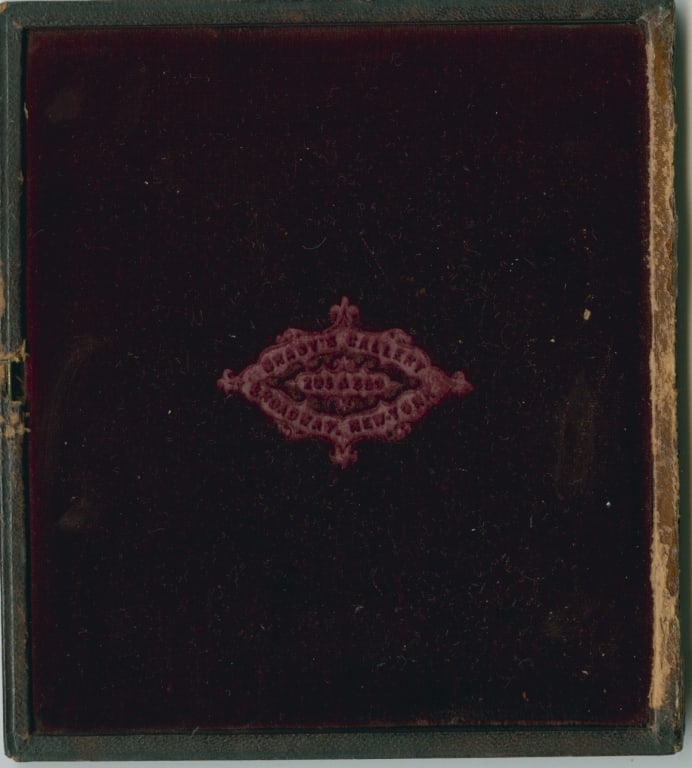 [DAG] BRADY'S GALLERY. YOUNG WOMAN IN BONNET: DAGUERREOTYPE. Brady's Gallery (New York). Portrait of young woman in bonnet and bow. Sixth plate in gilt frame. Red velvet lining on inside of upper stamped with Brady's mark. Red leather case, light